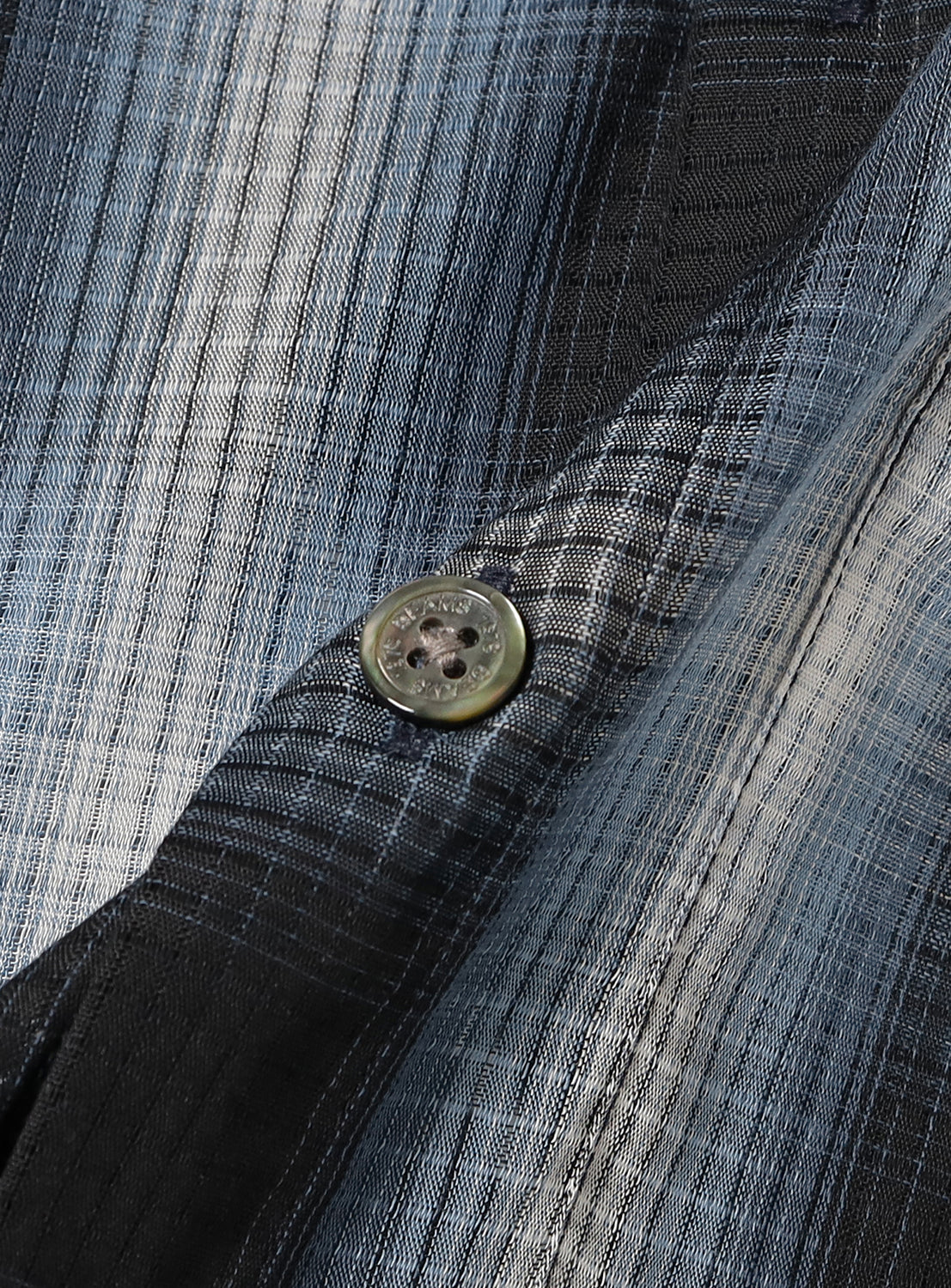 Close-up of a button on the plaid fabric. 