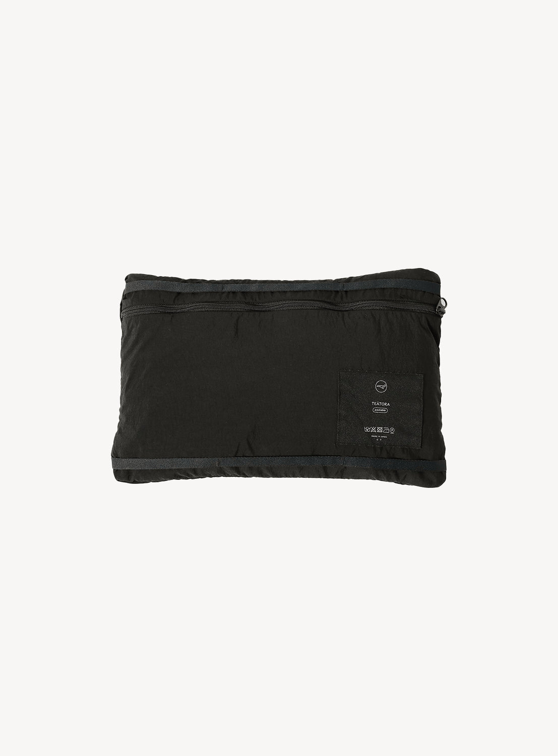 Black jacket neatly folded into a small square, showcasing its packable feature.