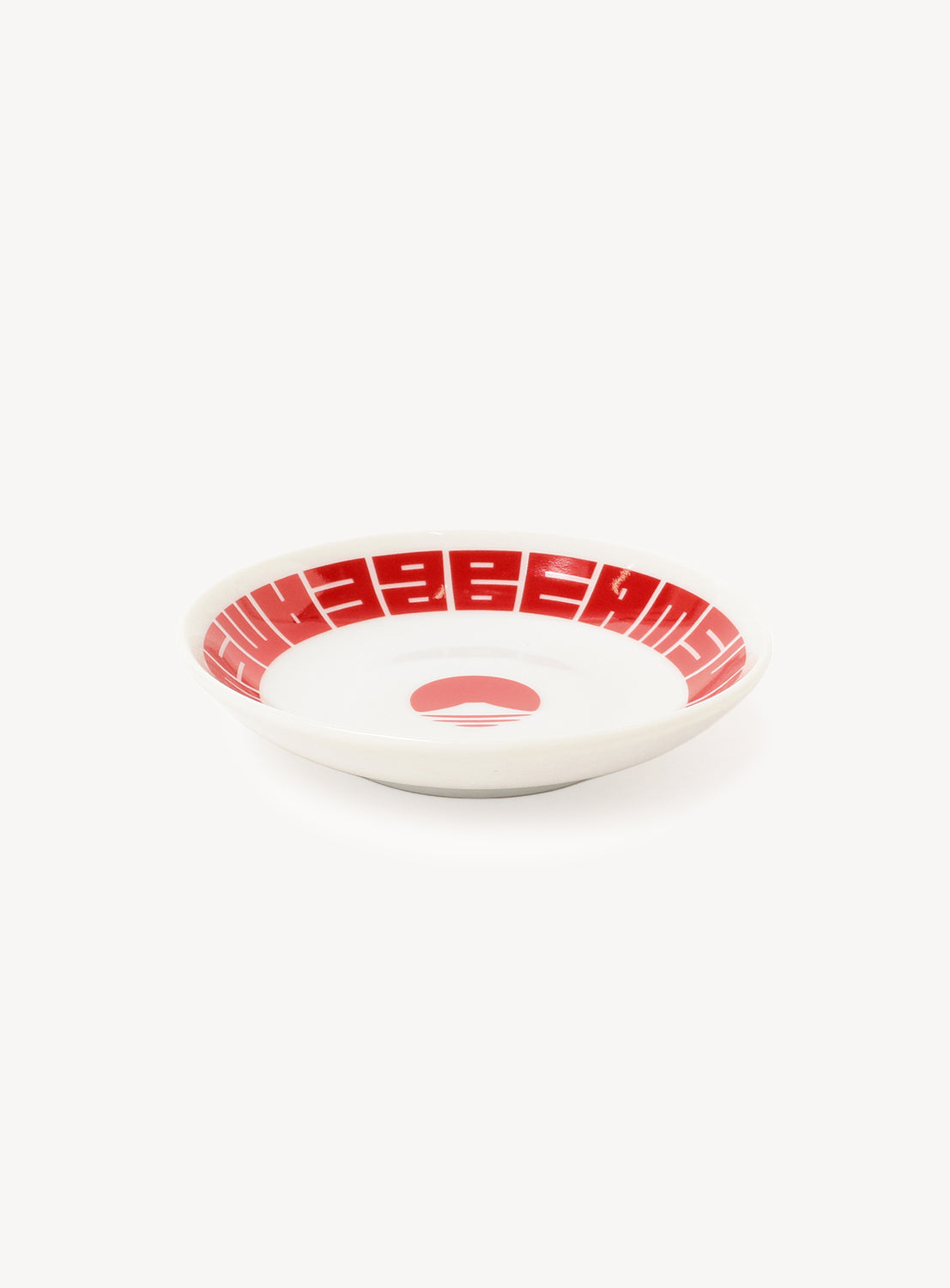 White plate with red geometric pattern on a white background