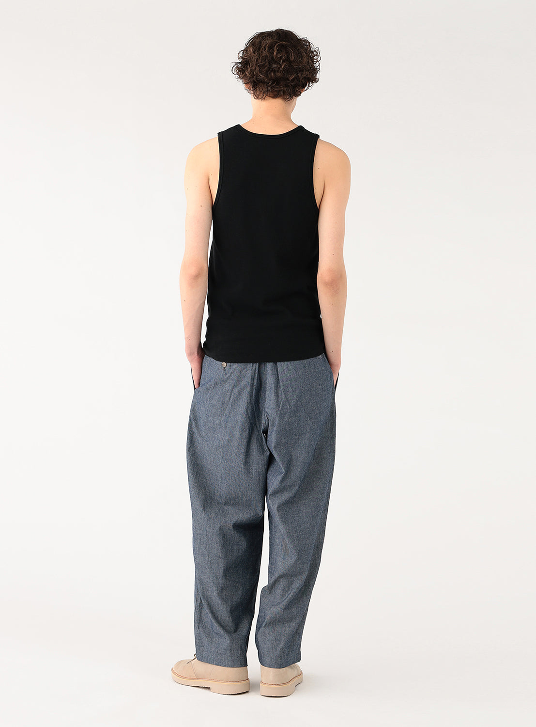 Model shown from behind, showcasing the classic racerback-style cut of the black sleeveless shirt.