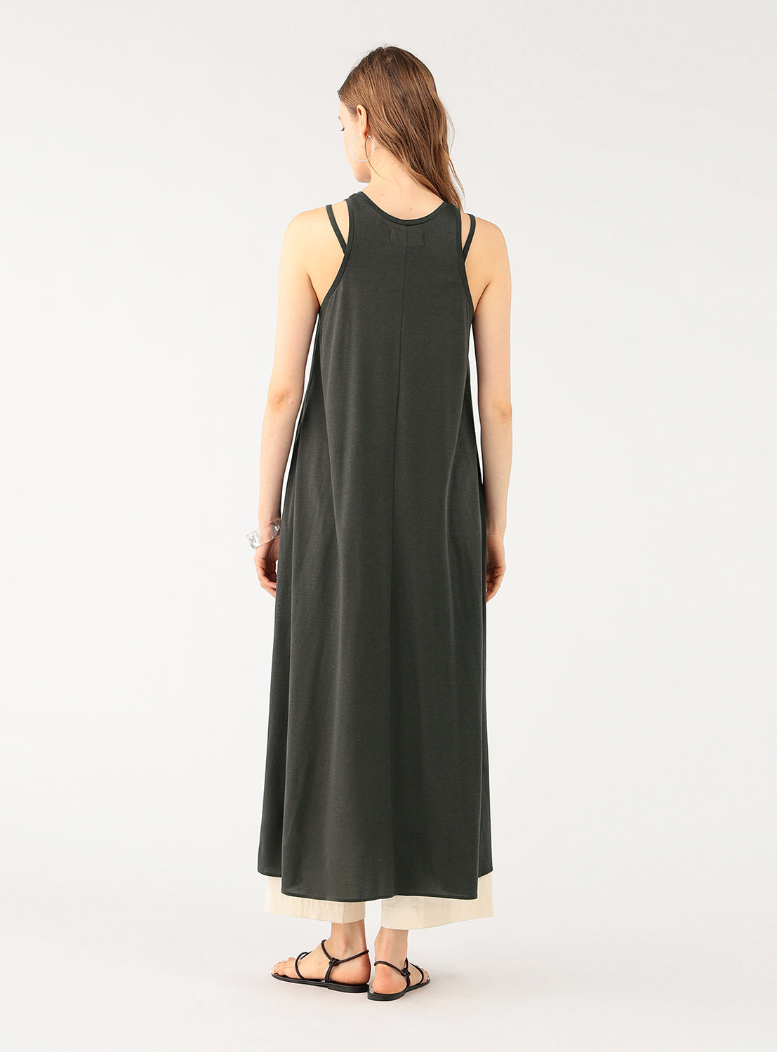Back view of a model wearing a grey maxi dress, showing the simple neckline and full-length design.