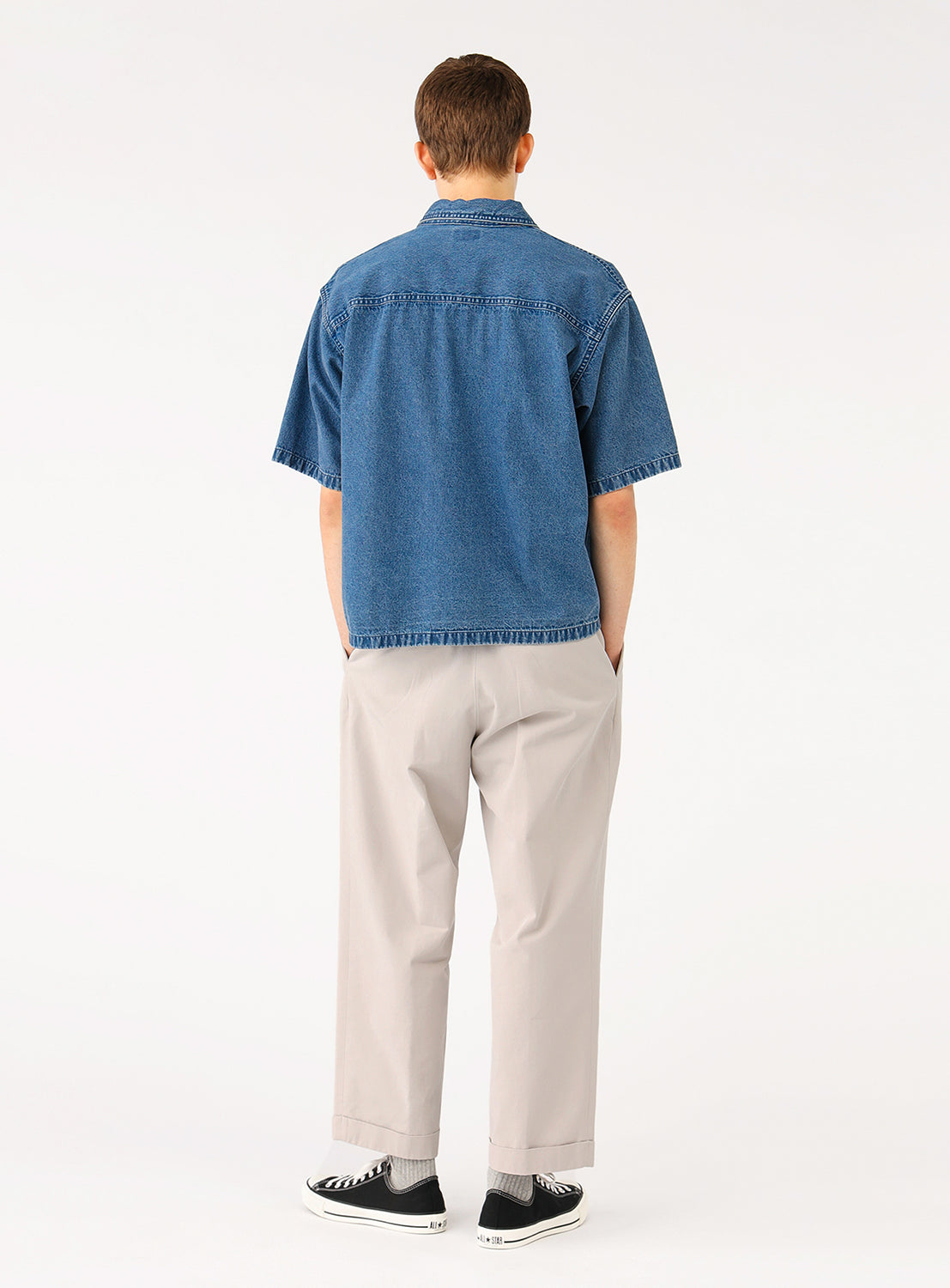 Rear view of model wearing the BEAMS Short Denim Shirt in blue indigo denim, showcasing the relaxed boxy fit and clean back silhouette.