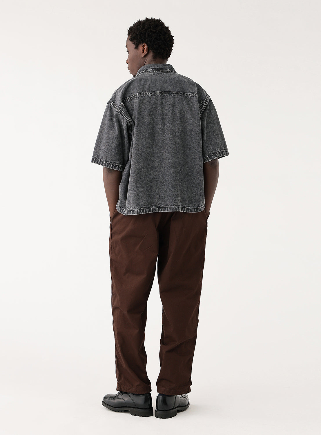 Rear view of model wearing the BEAMS Short Denim Shirt in black denim, showcasing the relaxed boxy fit and clean back silhouette.