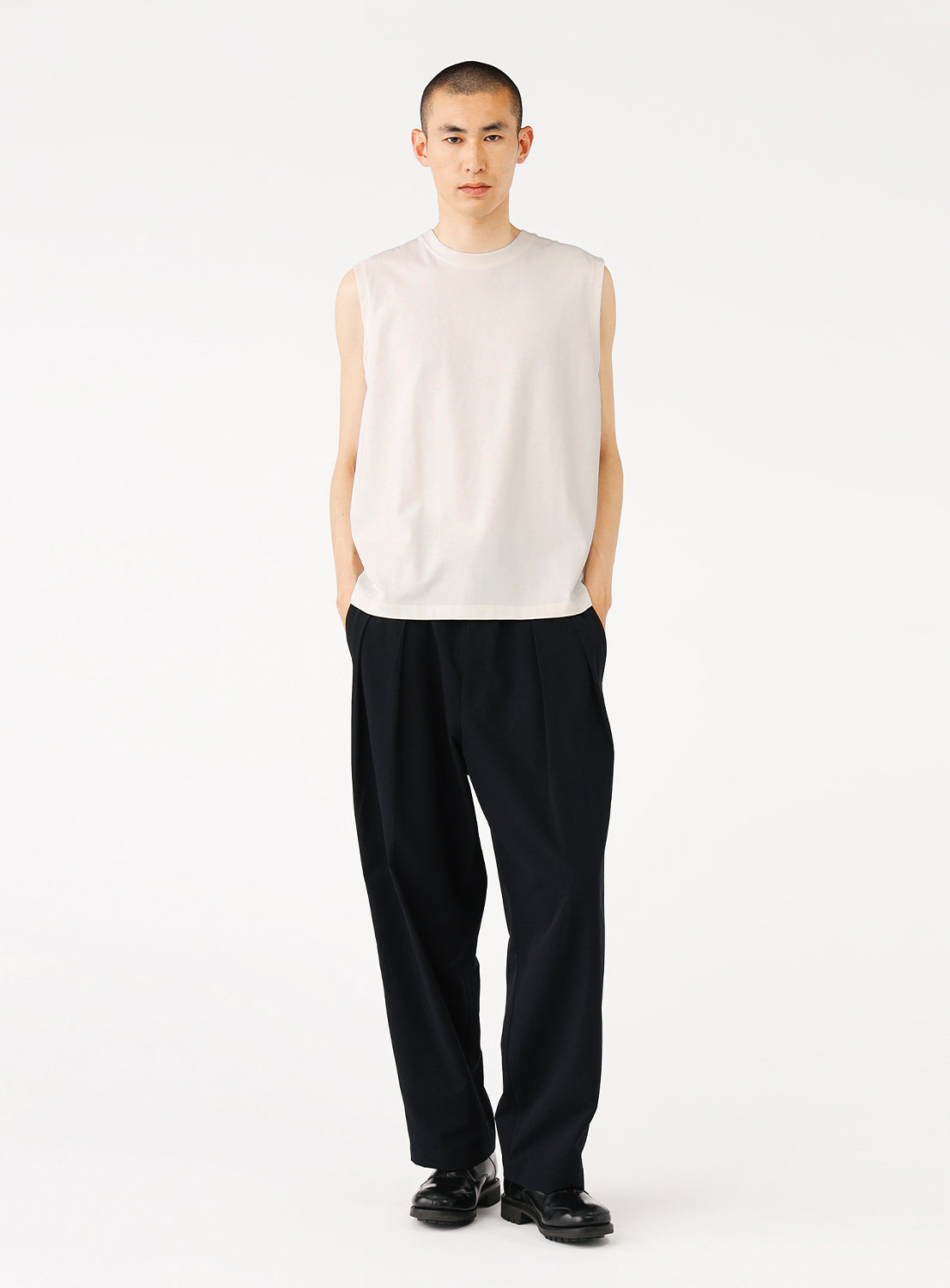 Model showcasing the front of the off-white tank top and a casual outfit.