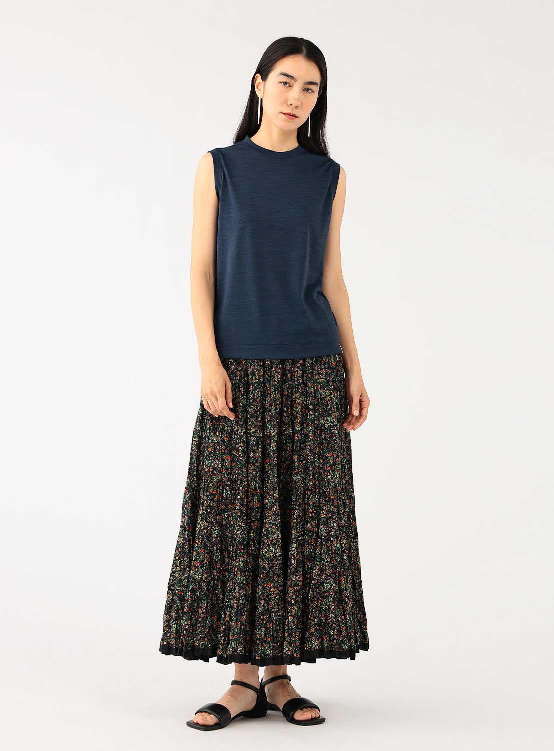 Full view of a model wearing a navy sleeveless top with a floral skirt.