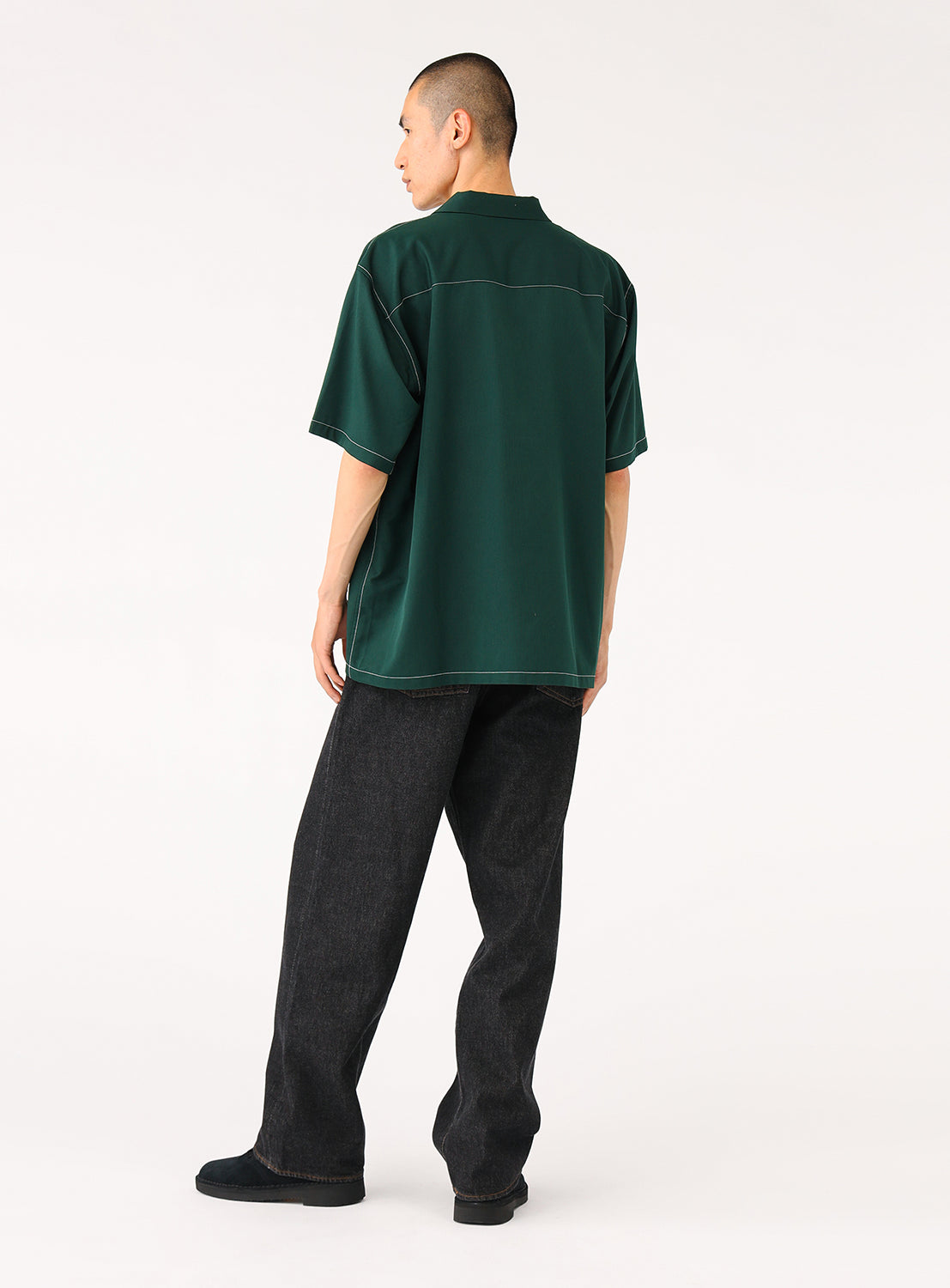 Back view of model wearing dark green BEAMS Stitching Easy Shirt with relaxed fit, tonal stitching, and lightweight polyester fabric.