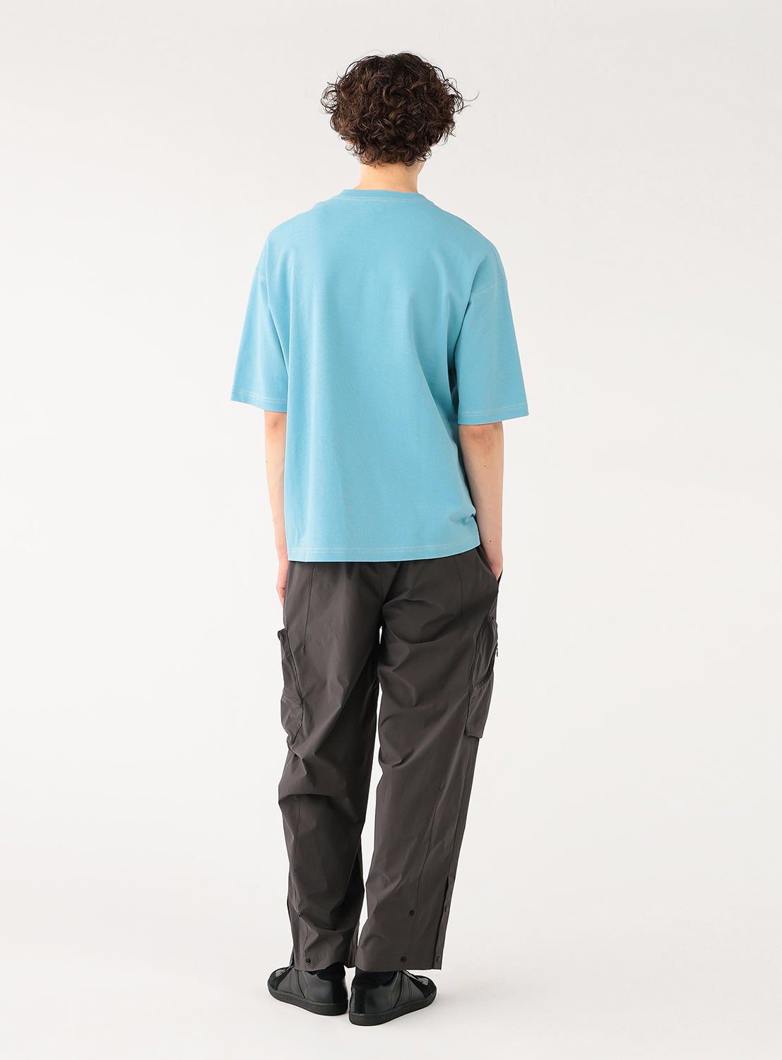 Back view of a model in the light blue t-shirt, showing the relaxed silhouette and fit.