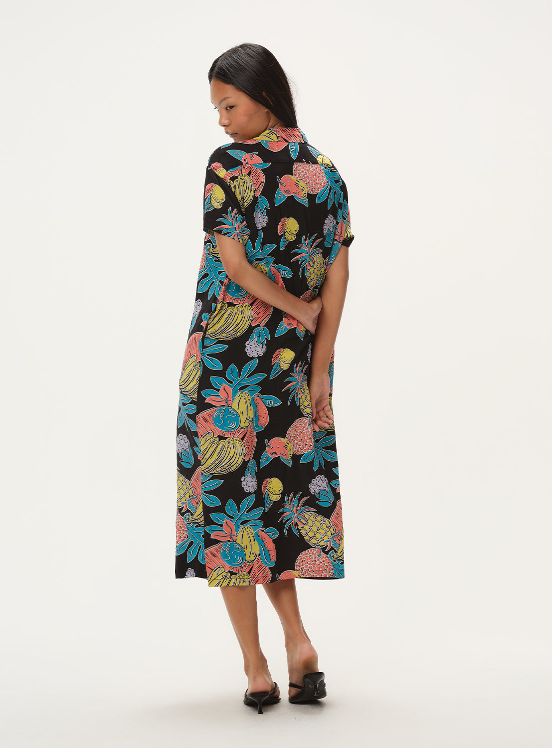 Back view of a model in the black patterned dress, showcasing the full length and design from behind.