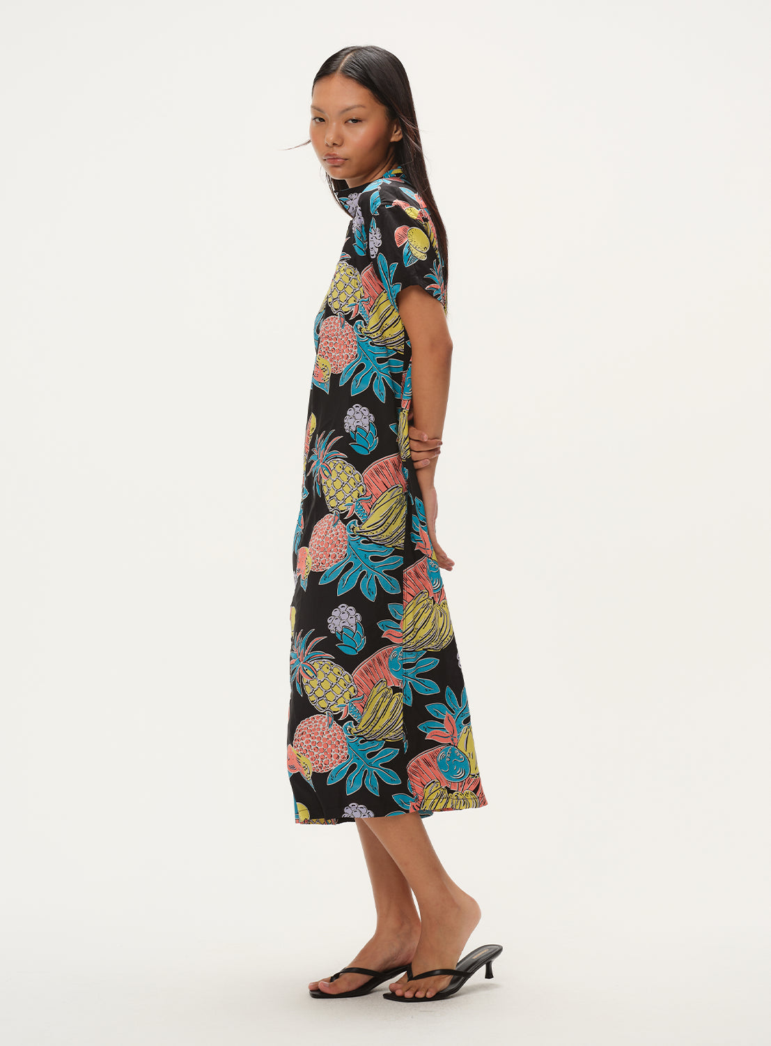 Side view of a model in the black patterned dress, showing the full length and flow of the fabric.