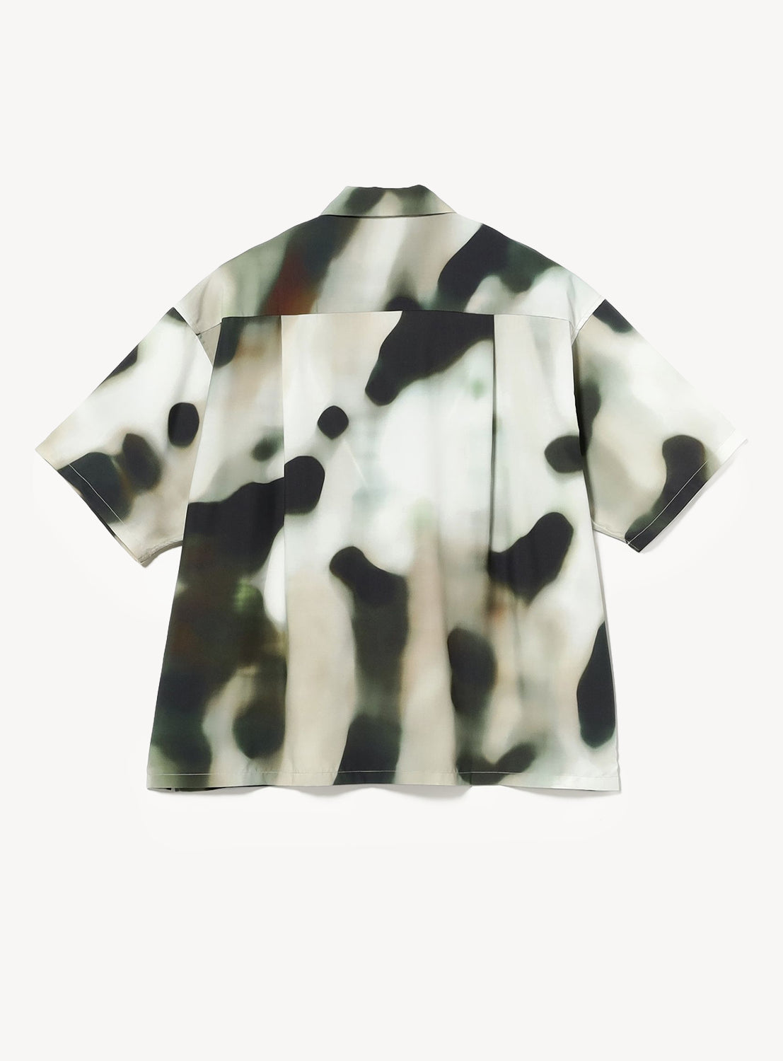 The BAL Blur Pattern Open-Collar Short-Sleeve Shirt features a loose fit and an abstract black, white, and olive-green camouflage design inspired by original textile artwork, shown against a white background.