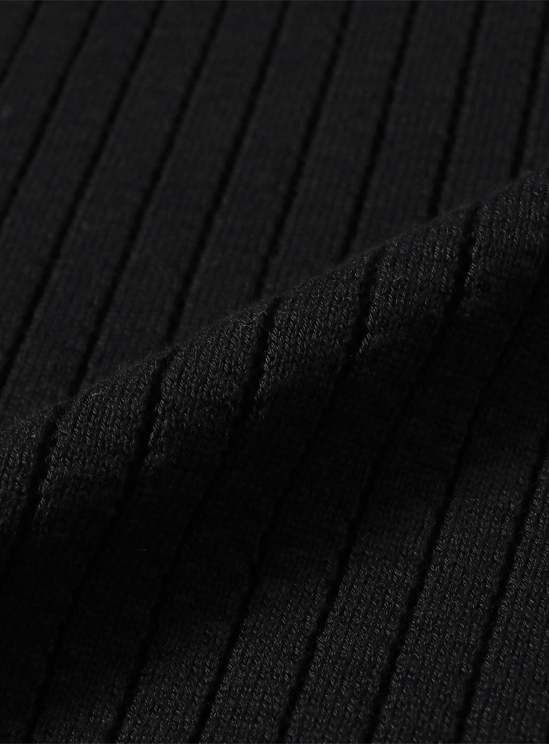 Close-up of black ribbed knit vest fabric, detailing the vertical ribbing and tight weave.