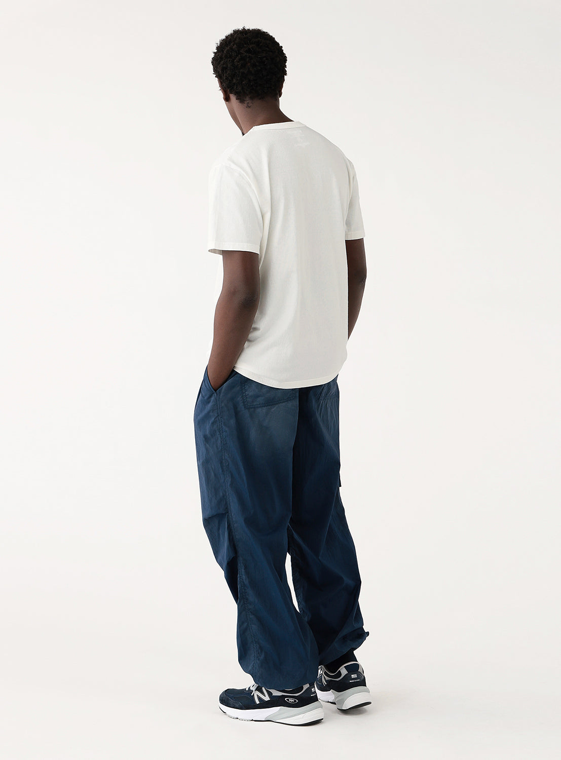 Model wearing a white t-shirt and blue jeans, back view, showcasing the plain back of the shirt.