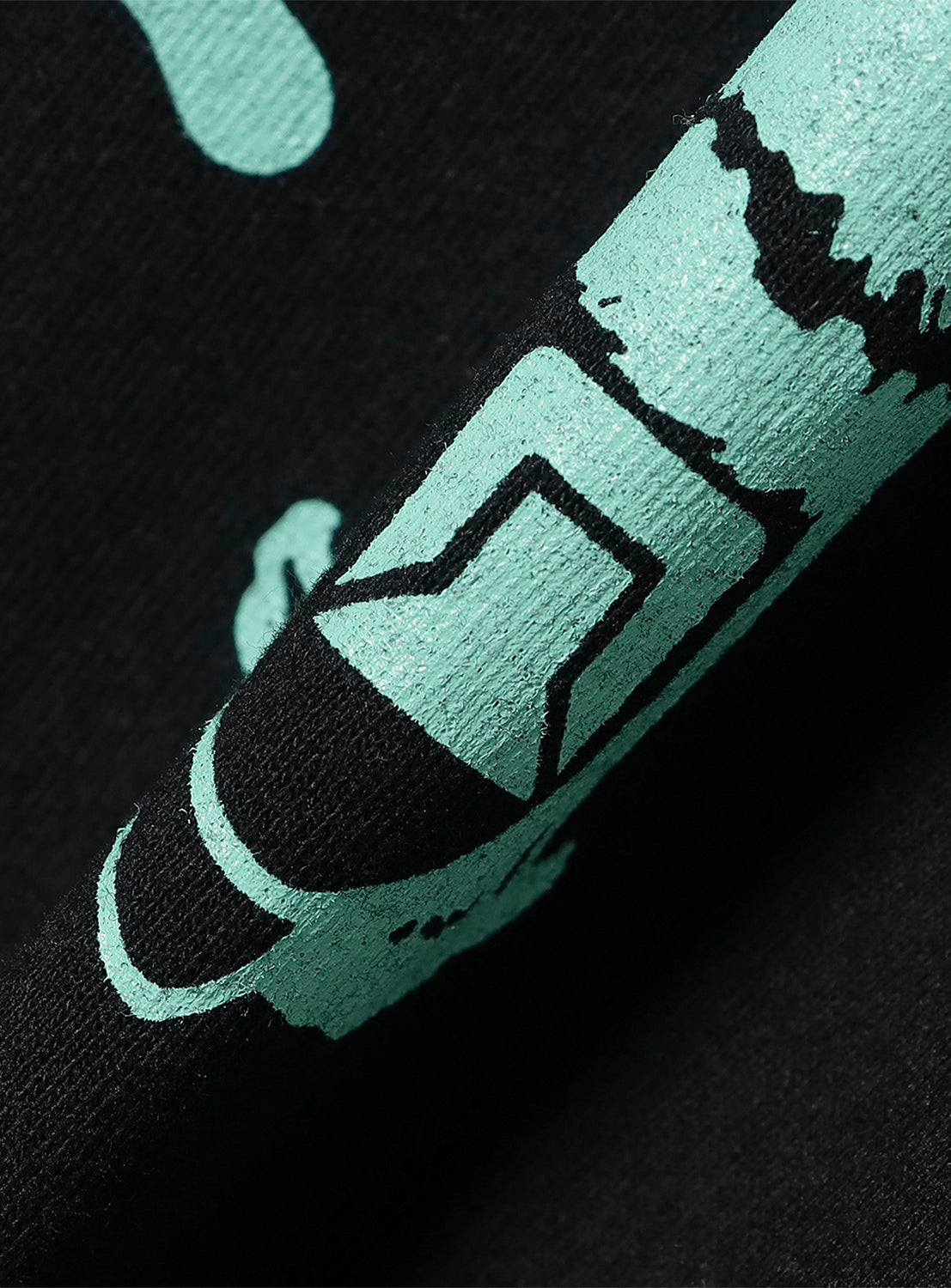 Close-up of black t-shirt fabric, detailing the mint green "Tacoma Fuji Records" graphic print.
