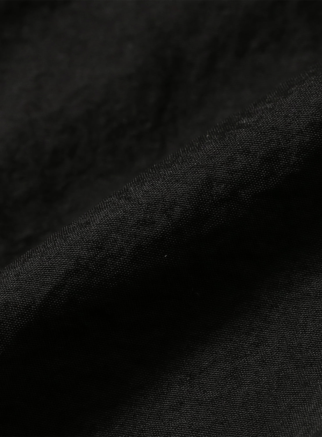Fabric detail of the black shorts, highlighting the micro-brushed nylon of the TEATORA PACKABLE series.