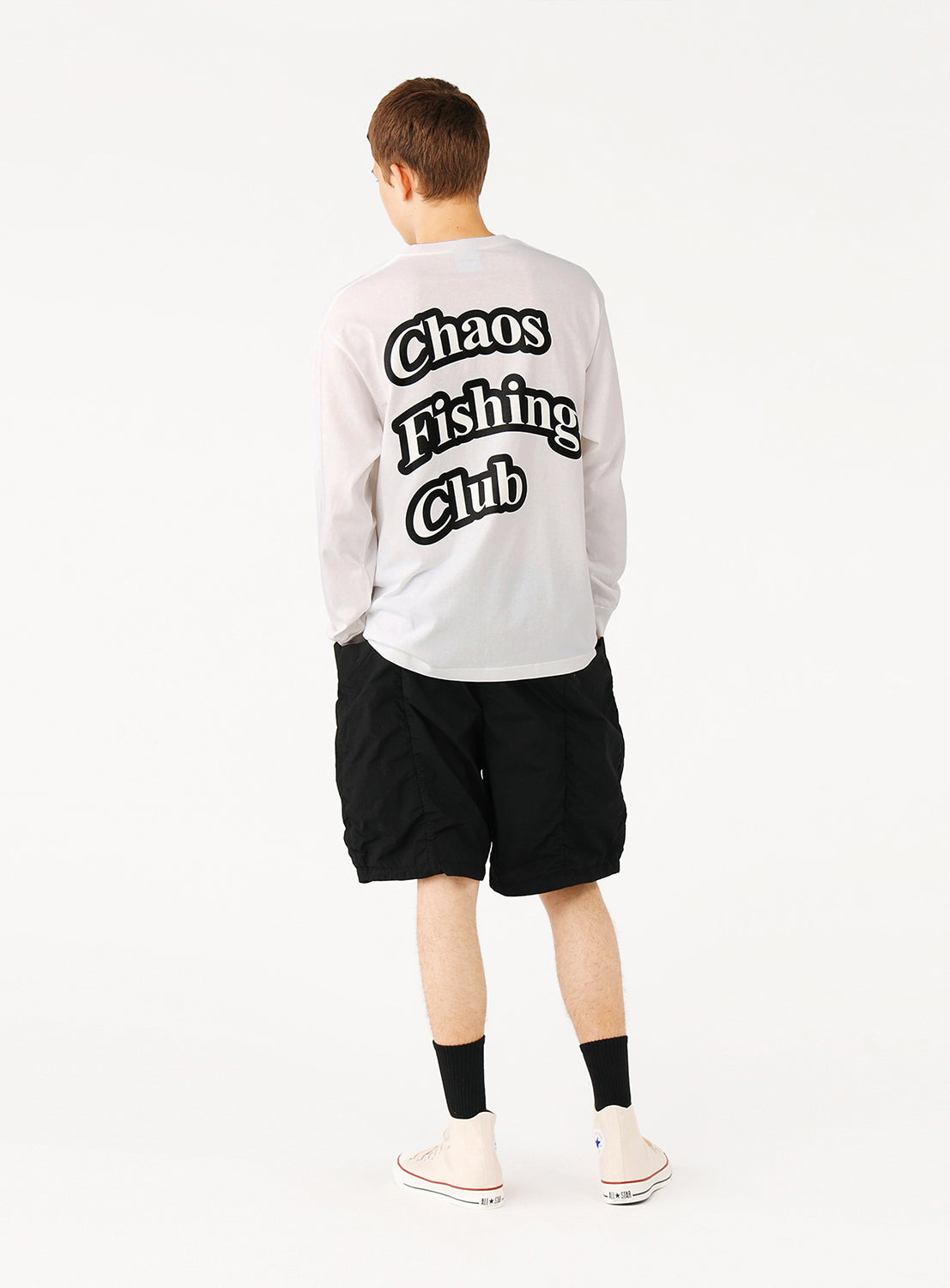 Back view of a model in black shorts, highlighting the clean silhouette and concealed utility.