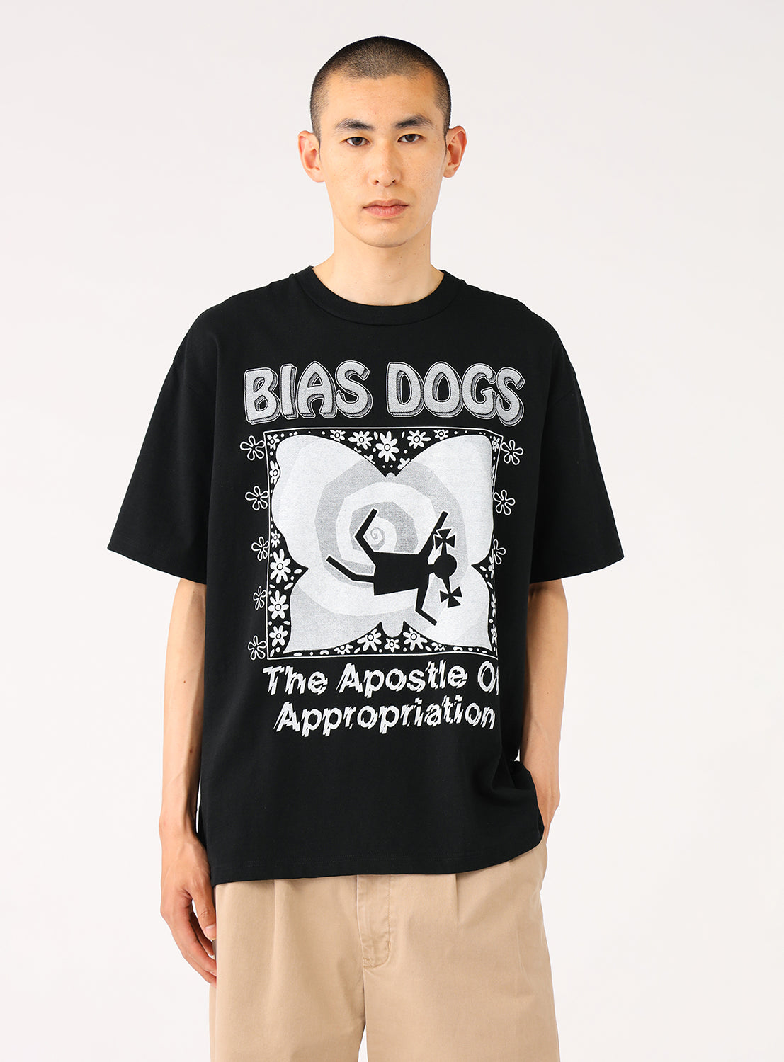 Model wearing a black t-shirt with "BIAS DOGS" graphic and khaki pants, front view, displaying casual fit.