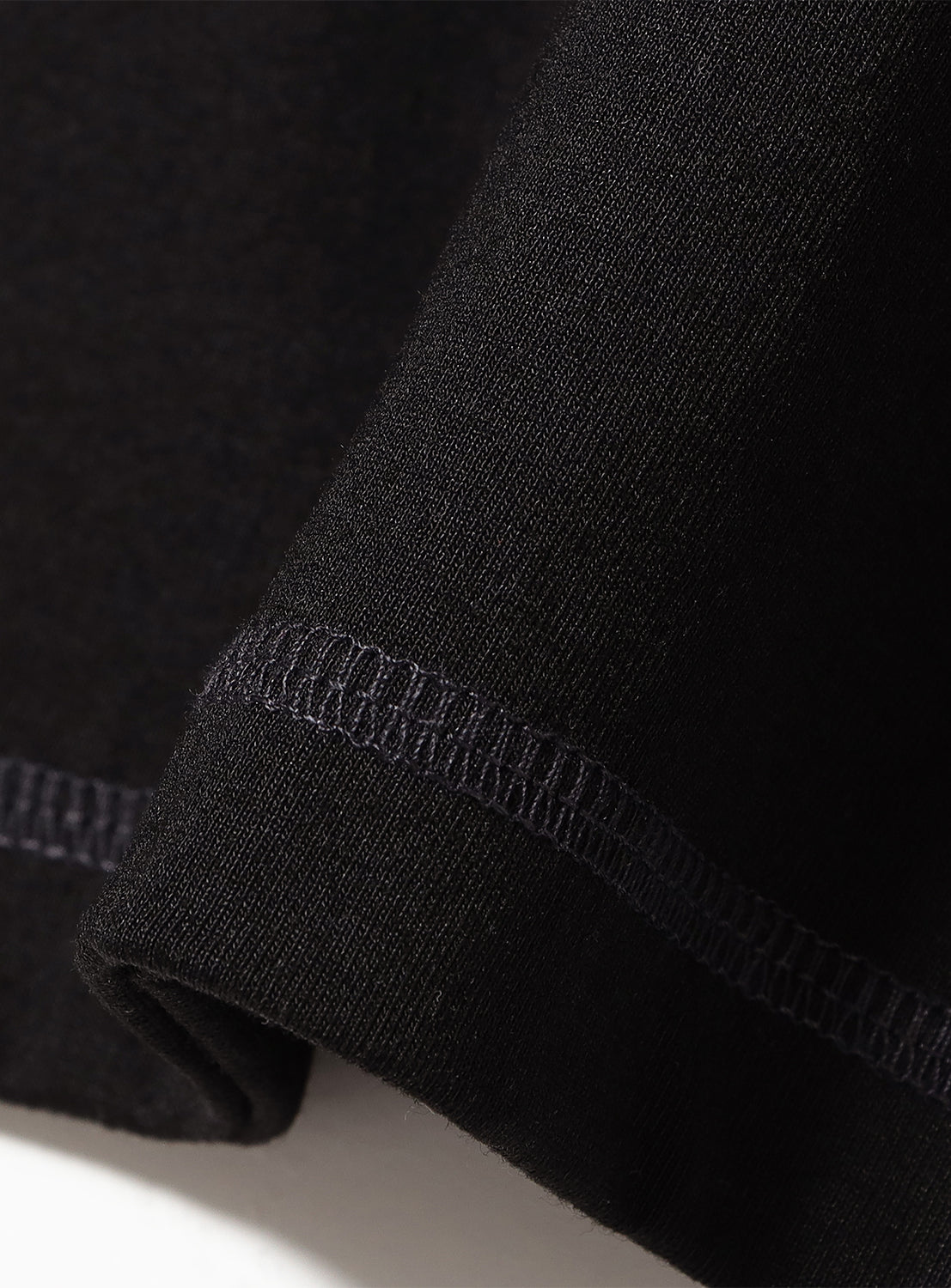 Close-up of a black shirt highlighting the stitching details. 
