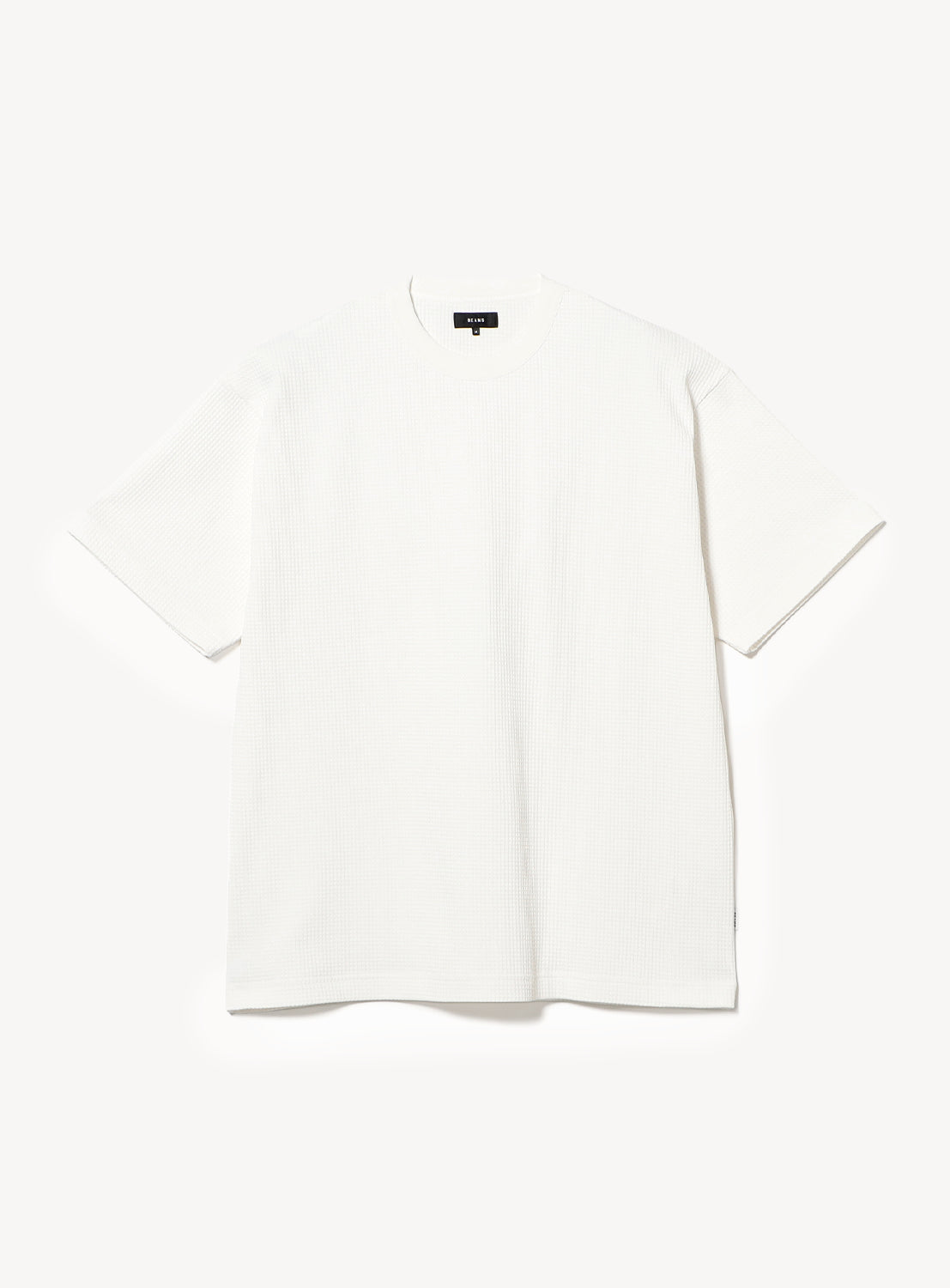 A BEAMS Stretch Waffle T-Shirt in plain white is laid flat on a white background. This short-sleeve top features a moisture-wicking, quick-drying crew neck design with a relaxed fit, and is finished with a small black tag at the collar.