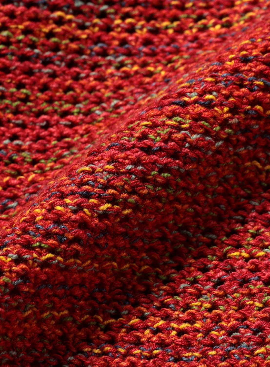 Close-up of a BEAMS 7-Gauge Mesh Crew Neck Top, featuring a gradient mesh knit with a thick, open-weave texture in shades of red, yellow, and blue.