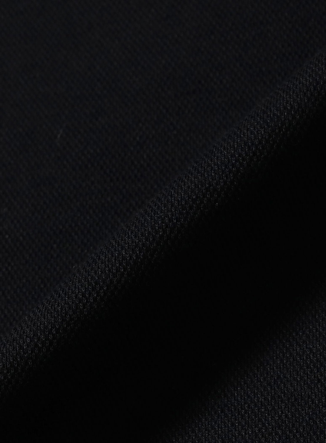 Close-up of the black pique fabric with a folded edge on an [Exclusive] BEAMS x Fred Perry Pique Long Sleeve Polo Shirt.