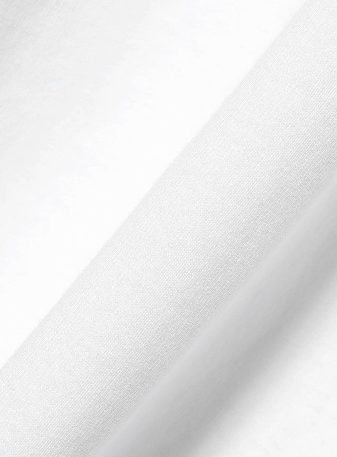 Close-up of the smooth, white fabric with a subtle fold highlights the soft texture and fine weave that make this CHAMPION [Exclusive] Mock Layered Long-Sleeve T-Shirt so comfortable.