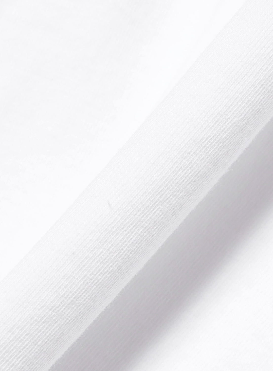 Close-up of folded white fabric on the BEAMS T Esteban Jefferson ‘Robert E. Lee’ Graphic T-Shirt, highlighting its smooth texture and fine weave—crafted from heavyweight US-grown cotton.