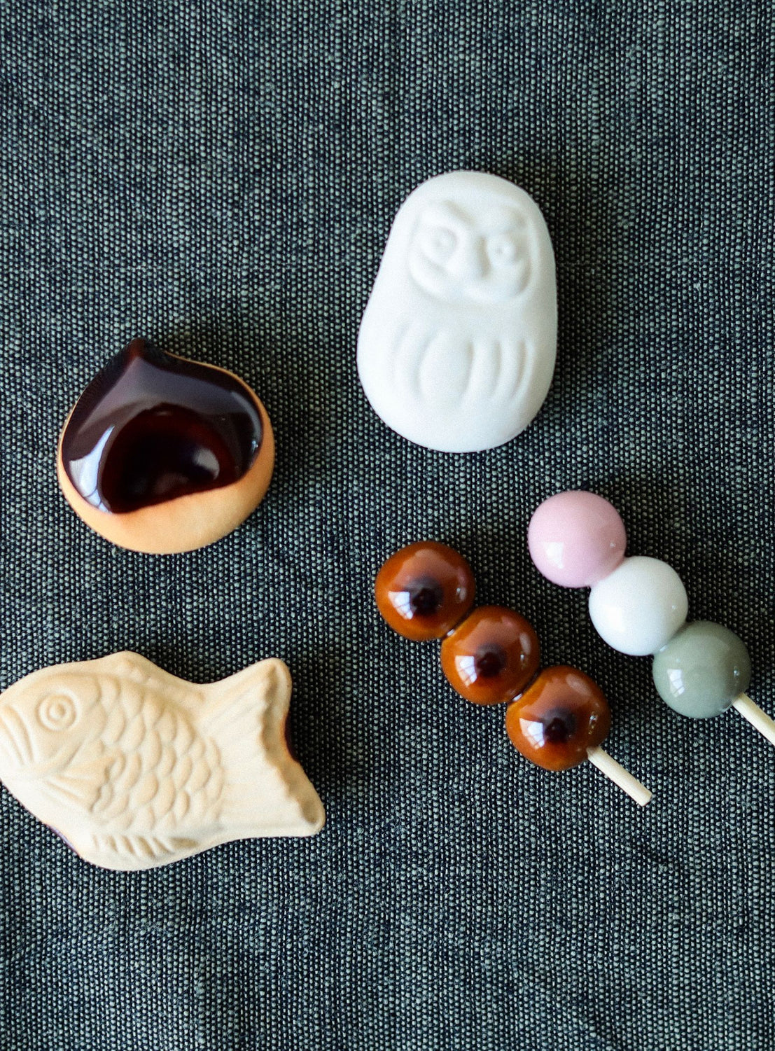 Assorted confectionery item chopsticks on a dark textured surface.
