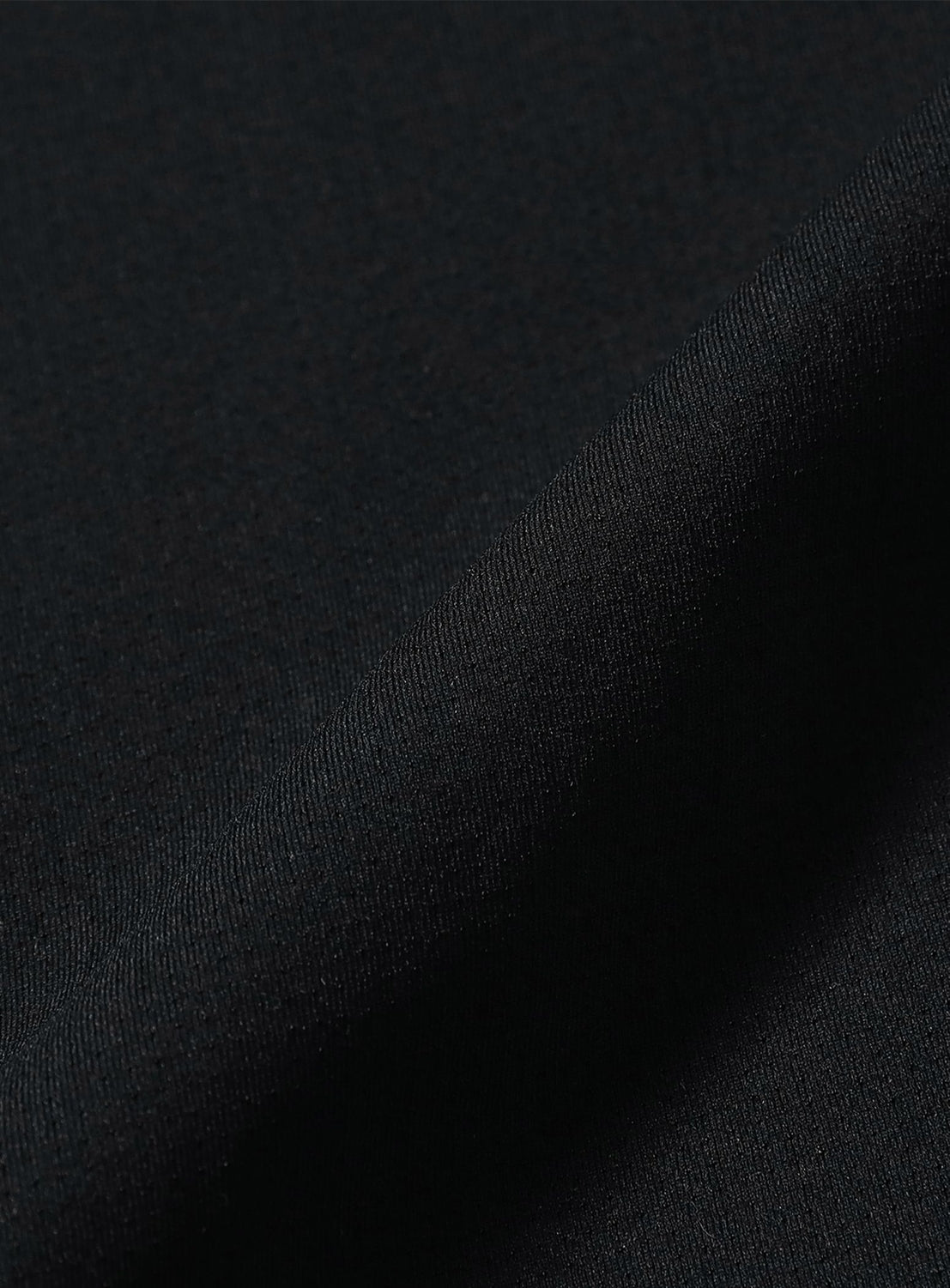 A close-up of the dark, textured fabric from BEAMS' Wide Straight Fit Dynamic Dry Easy Pants, featuring a soft diagonal fold that highlights the smooth weave and quick-drying surface.