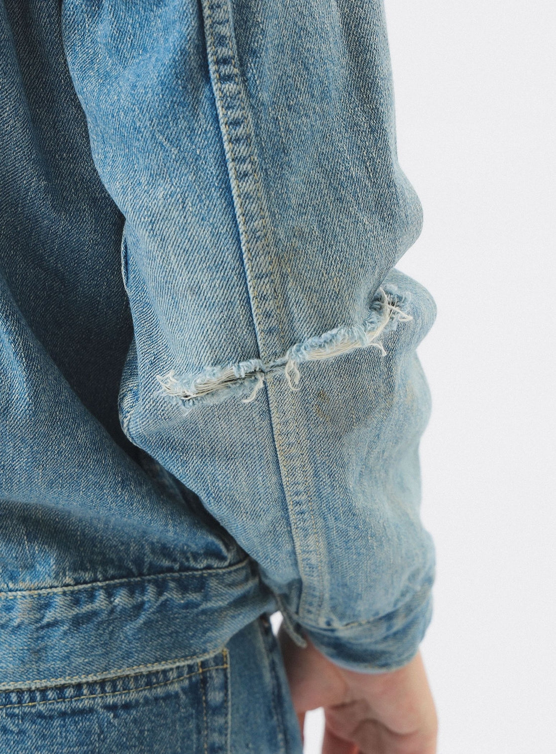 Close-up of a blue denim jacket with a white background