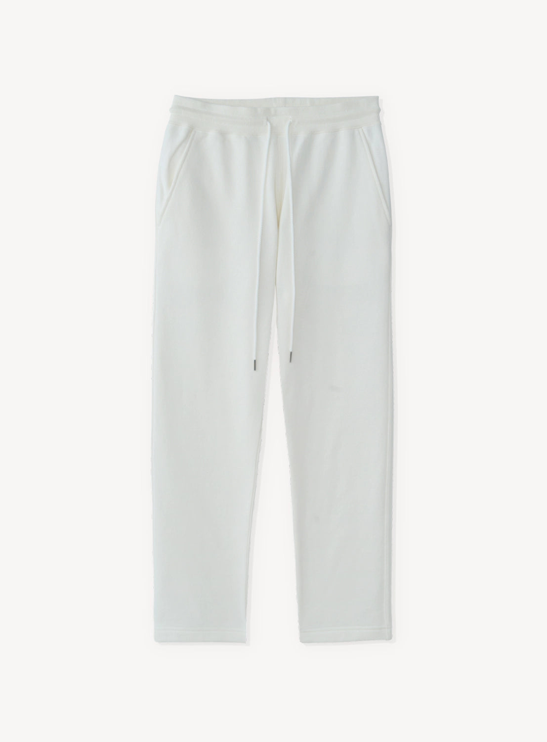 White tapered pants with a drawstring at the waist. 