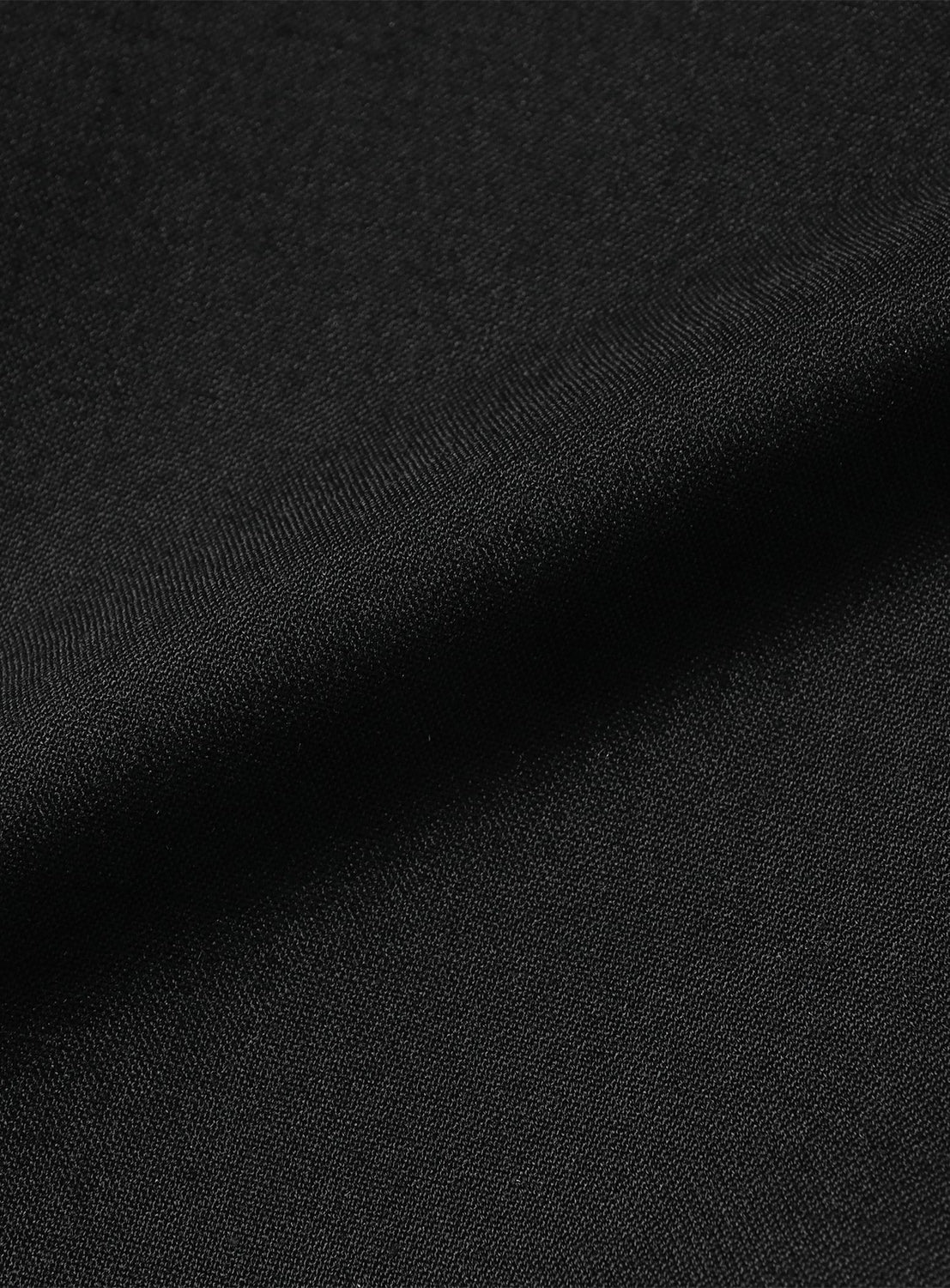 Close-up of the black BEAMS Easy-Wear Relaxed Fit Wide Slacks, showing wrinkle-resistant fabric with a subtle texture and a soft diagonal fold.