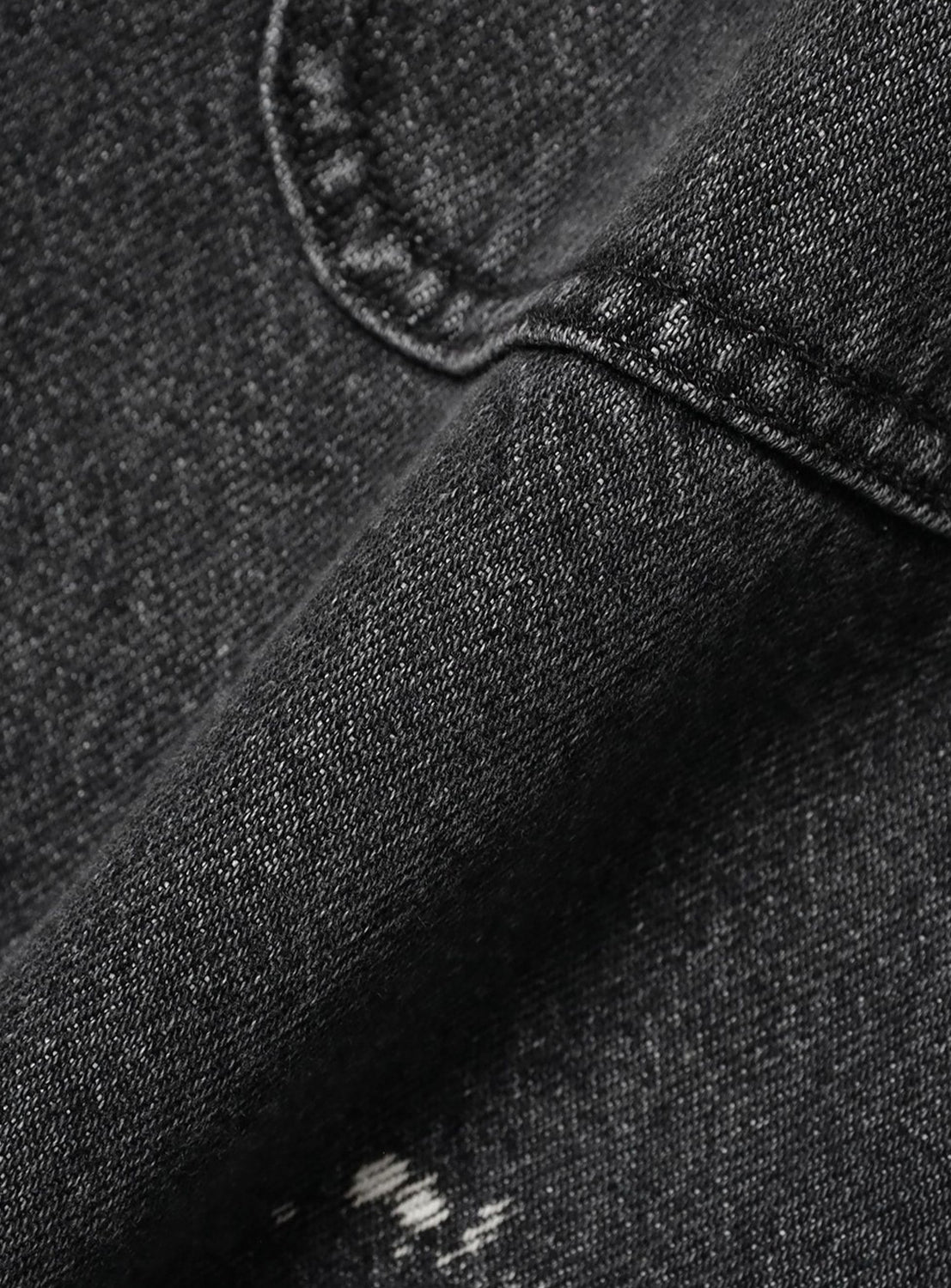 Close-up of the BEAMS Used Denim Coverall, featuring black denim fabric with a pocket seam and distressed, vintage-inspired details.