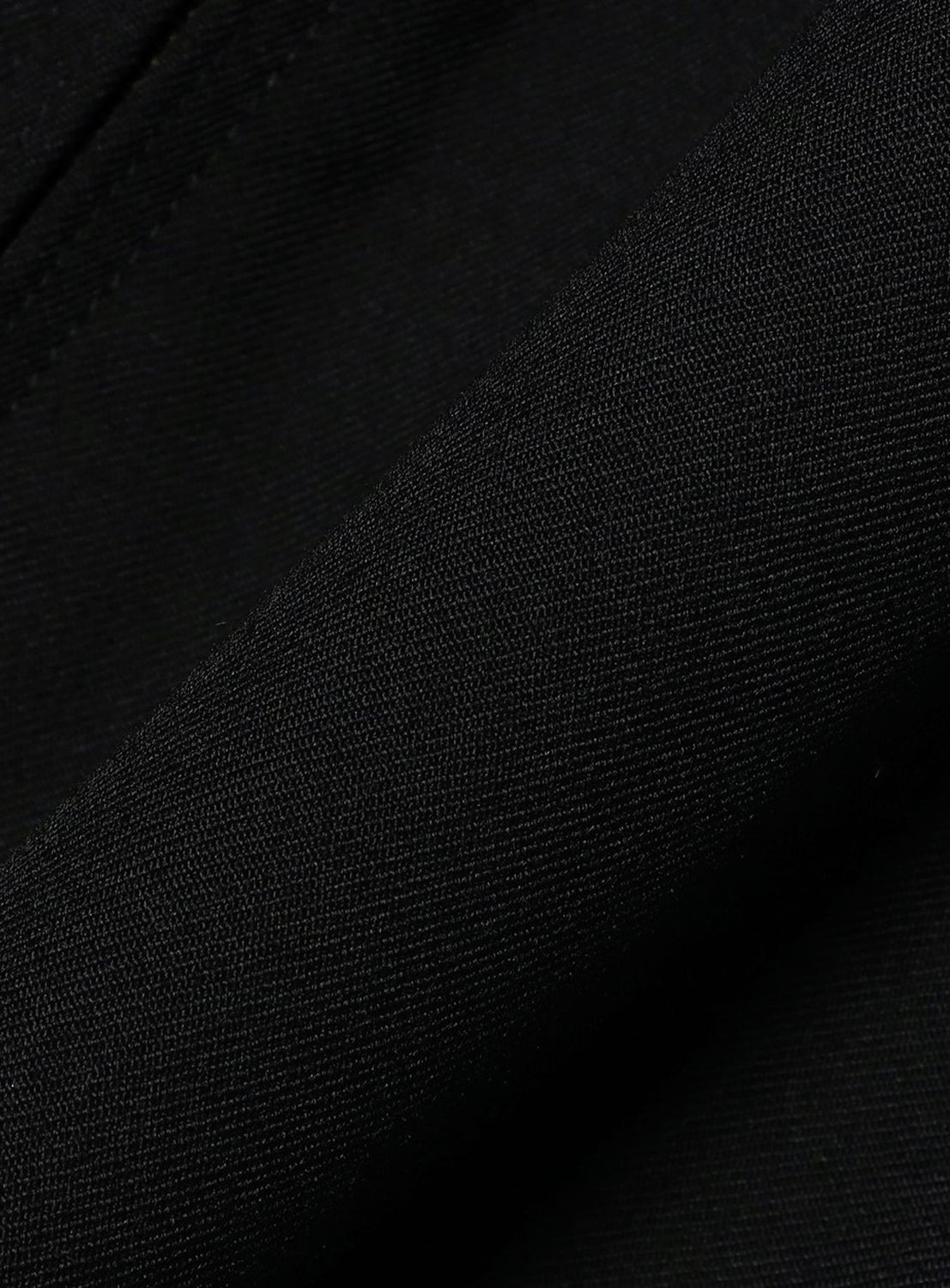 Close-up of the black wool gabardine fabric of a Gabardine Zip Blouson by BEAMS, showing a visible diagonal weave.