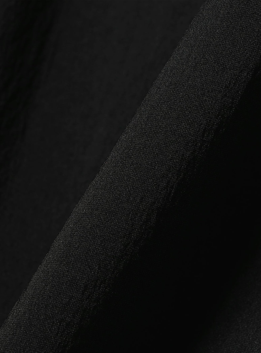 Close-up of a black TEATORA Wallet Jacket Plus - Doctoroid with a subtle textured weave, shown in a fold.