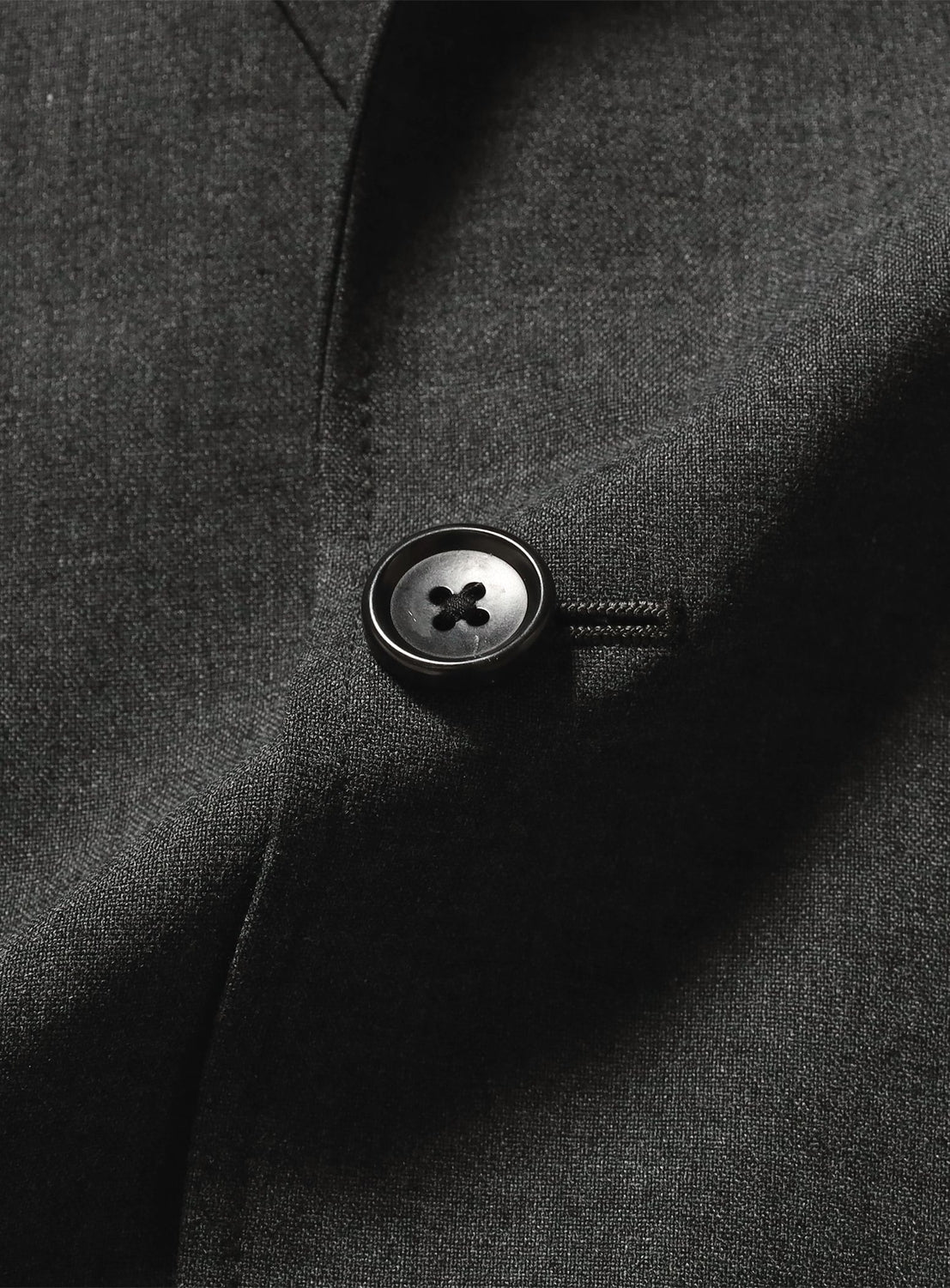 Close-up of a wrinkle-resistant, charcoal gray BEAMS Renewool Jacket featuring a single black four-hole button.