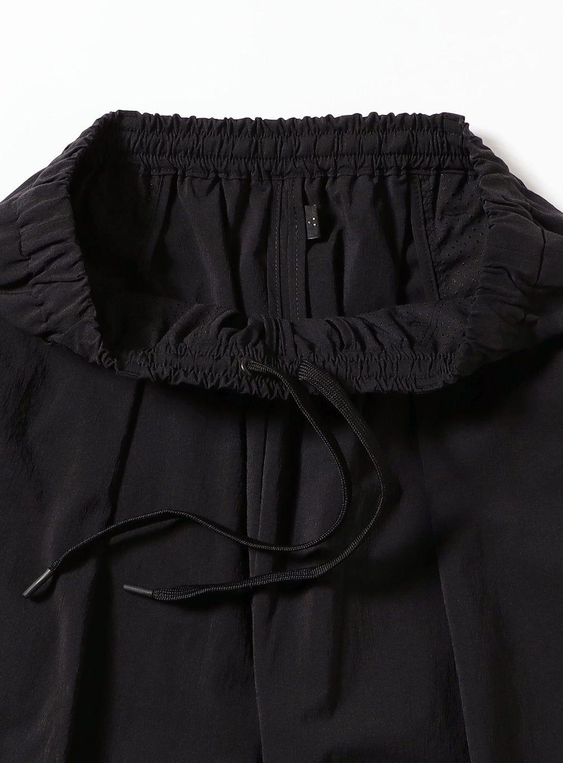 Close-up of TEATORA Wallet Pants Resort - Doctoroid in black, crafted from innovative DOCTOROID fabric with an elastic waistband and drawstring, displayed on a white background.