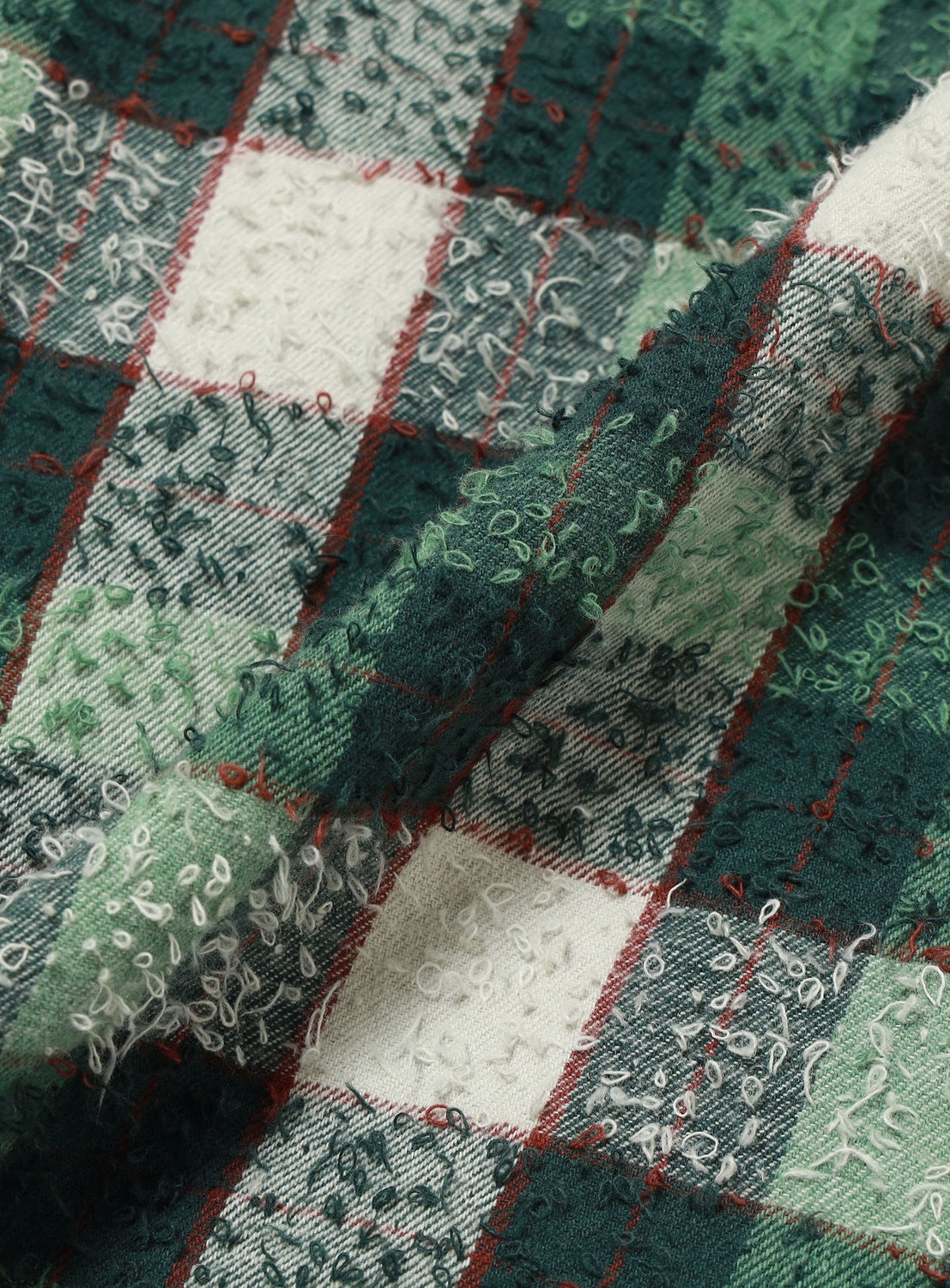 Close-up of the green, cream, and dark red textured, looped plaid fabric of a BEAMS Bouclé Flannel Hooded Shirt.