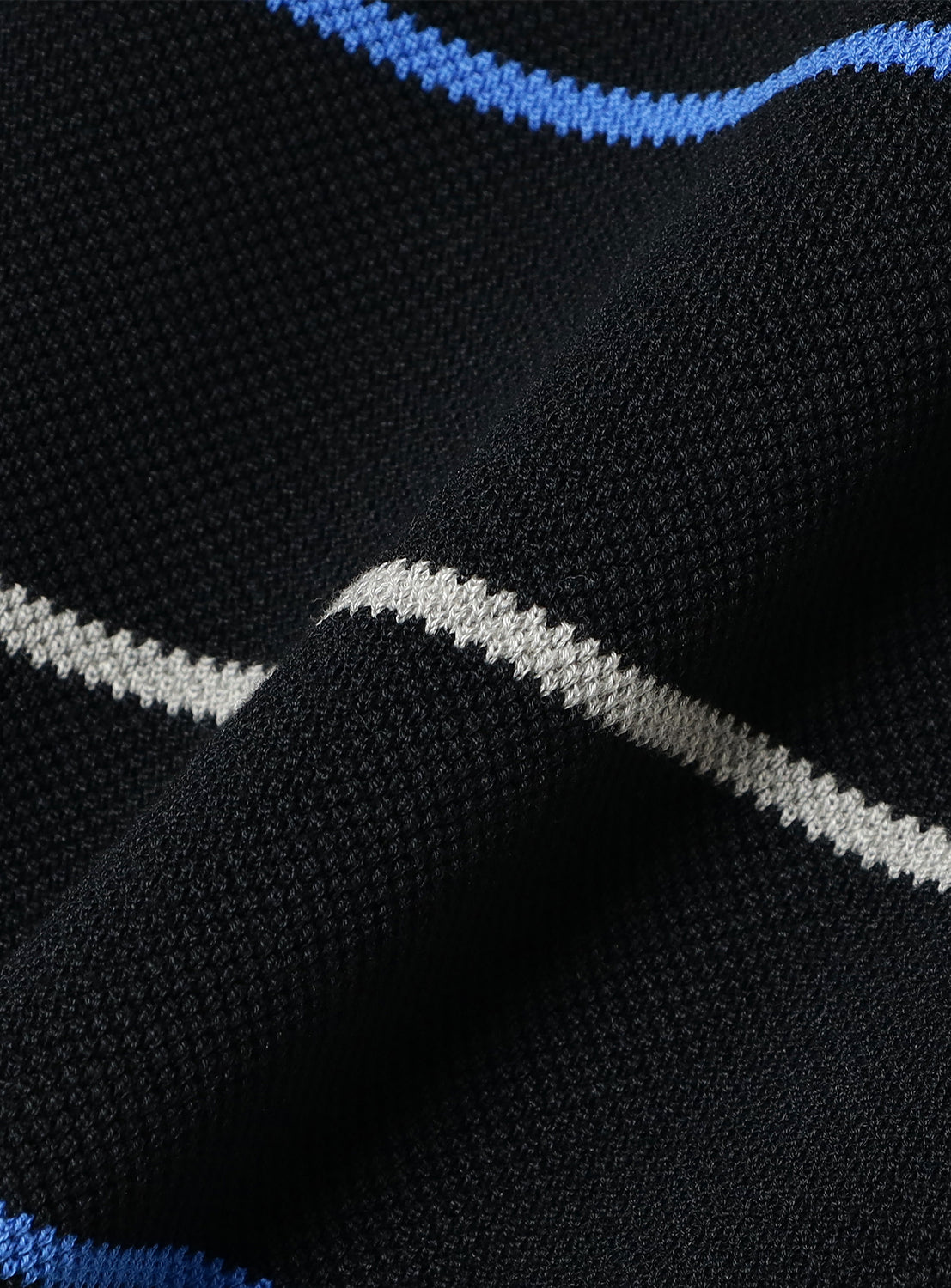 Close-up of black knit fabric, detailing the texture and horizontal blue and white  stripes.