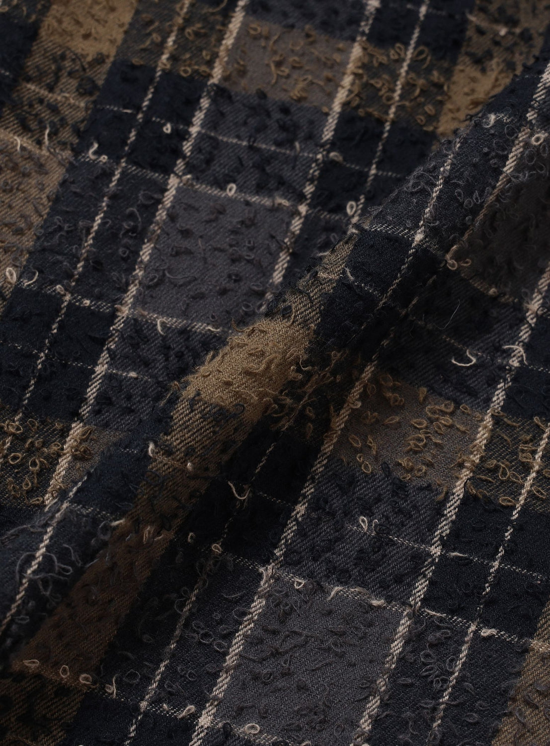 Close-up of a BEAMS Bouclé Flannel Hooded Shirt in dark olive and navy blue plaid, featuring a textured, looped surface.