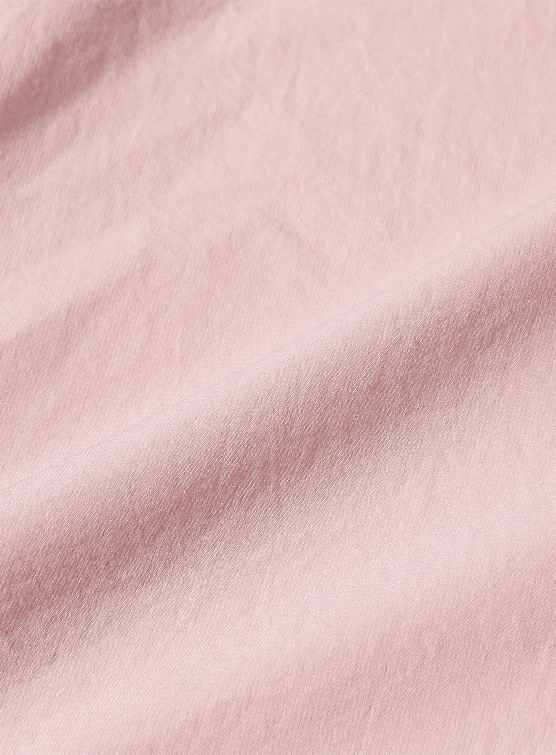 Close-up of soft folds in light pink water-repellent fabric of Technical 2-Way Adjustable Easy Pants.