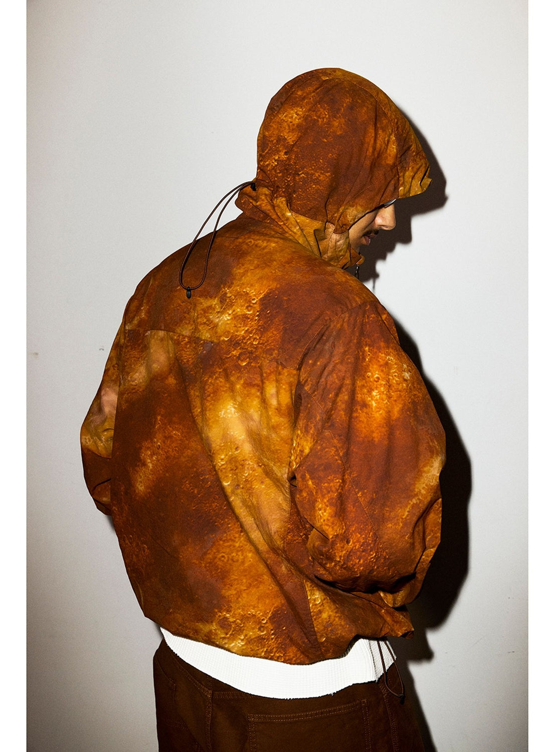 Person wearing a wide fit, lightweight Print Zip Hooded Jacket in an orange and brown mottled print.