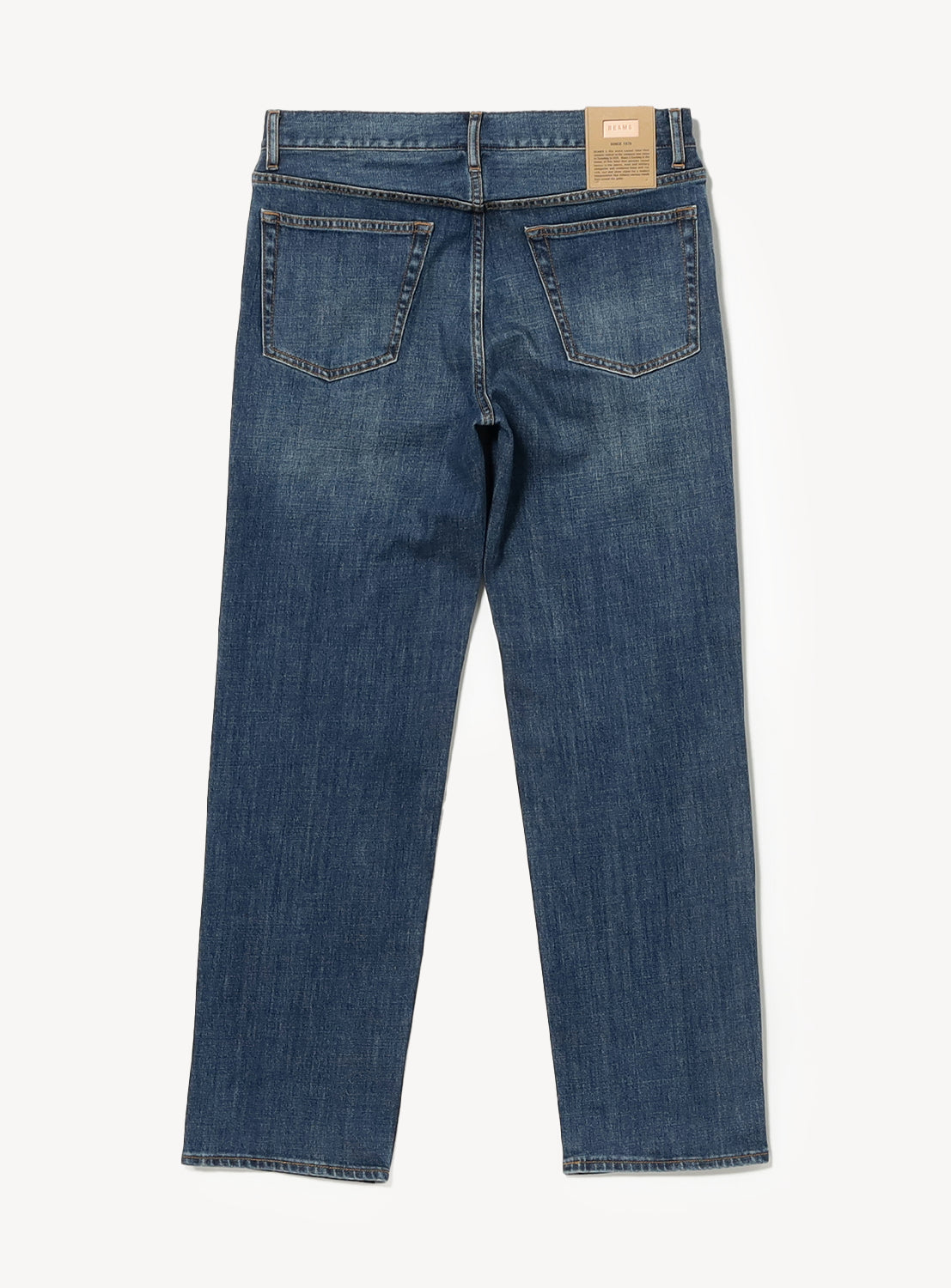 Back view of slim fit BEAMS Comfy 5-Pocket Denim jeans featuring two back pockets and a leather waistband patch.
