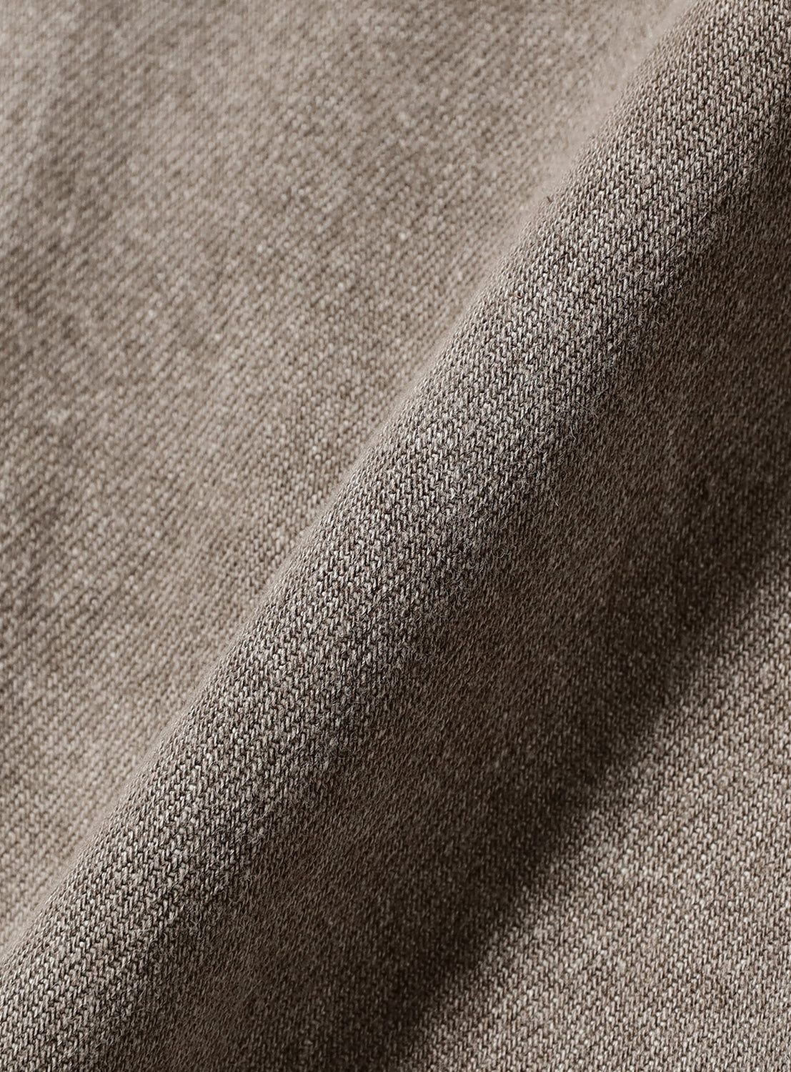 Close-up of a BEAMS Hooded Trucker Denim Jacket showing faded Japanese denim fabric with a visible weave and a diagonal fold.