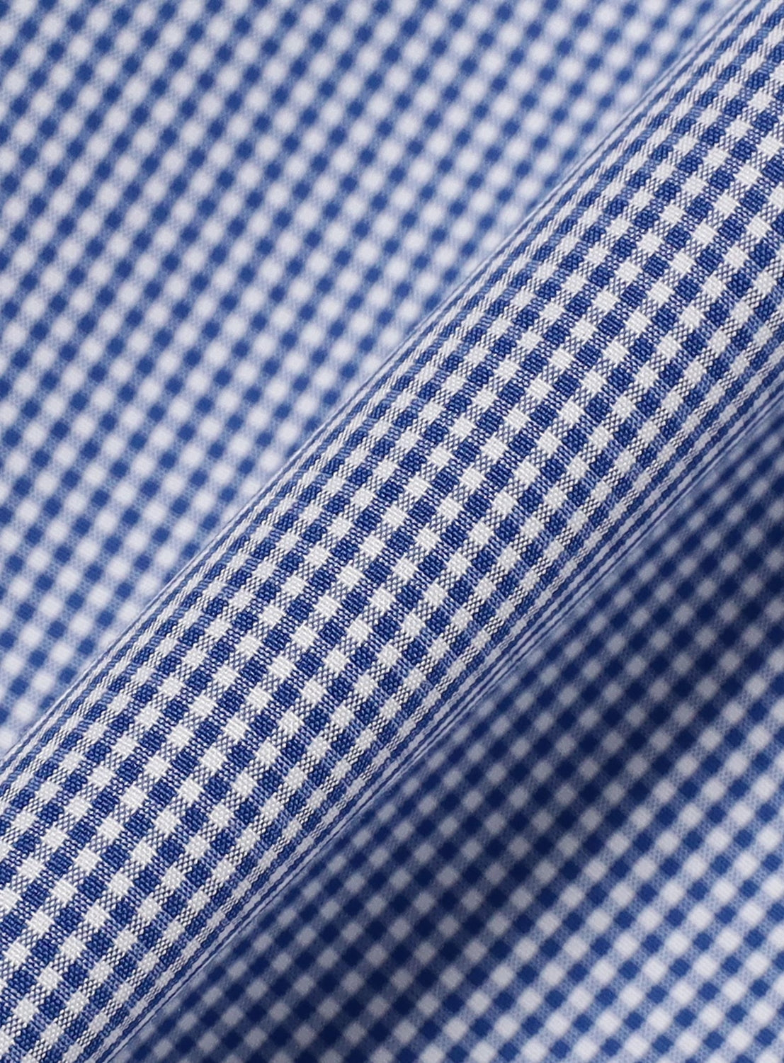 Close-up of blue and white gingham fabric with a small checkered pattern, shown at an angle to highlight the texture and weave of the material—perfect for crafting a modern silhouette like the TTT MSW I Love My Dog Half Sleeve Shirt.