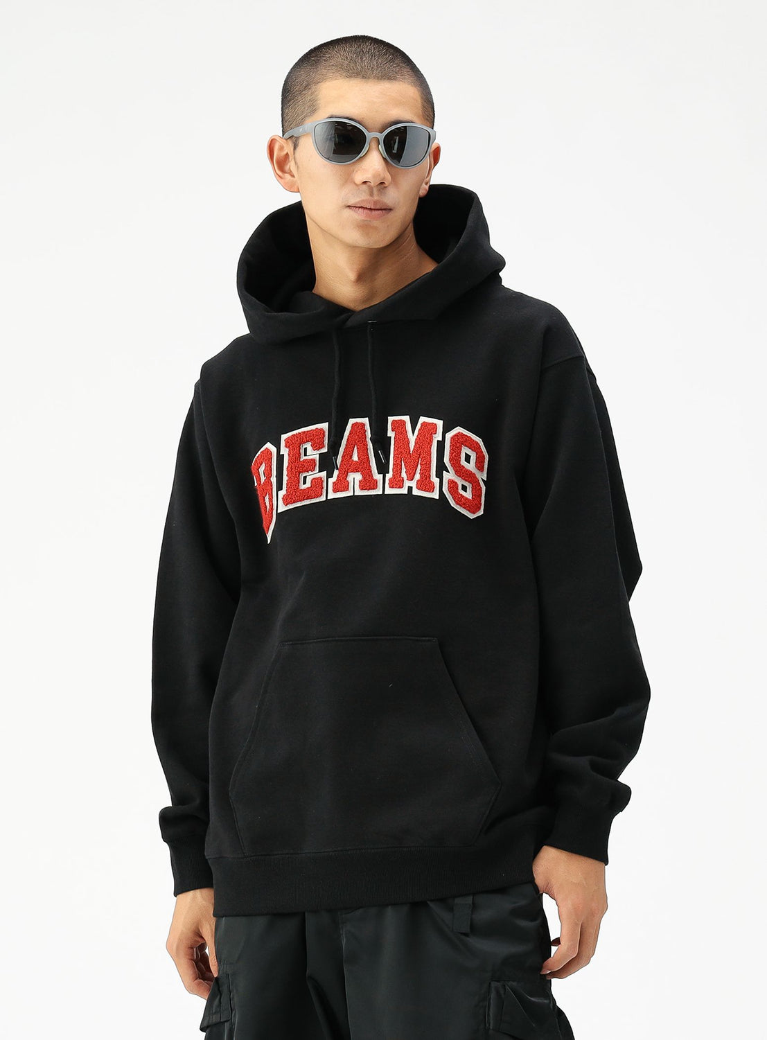 A person wearing sunglasses and a black BEAMS Basic Hoodie stands against a plain white background.