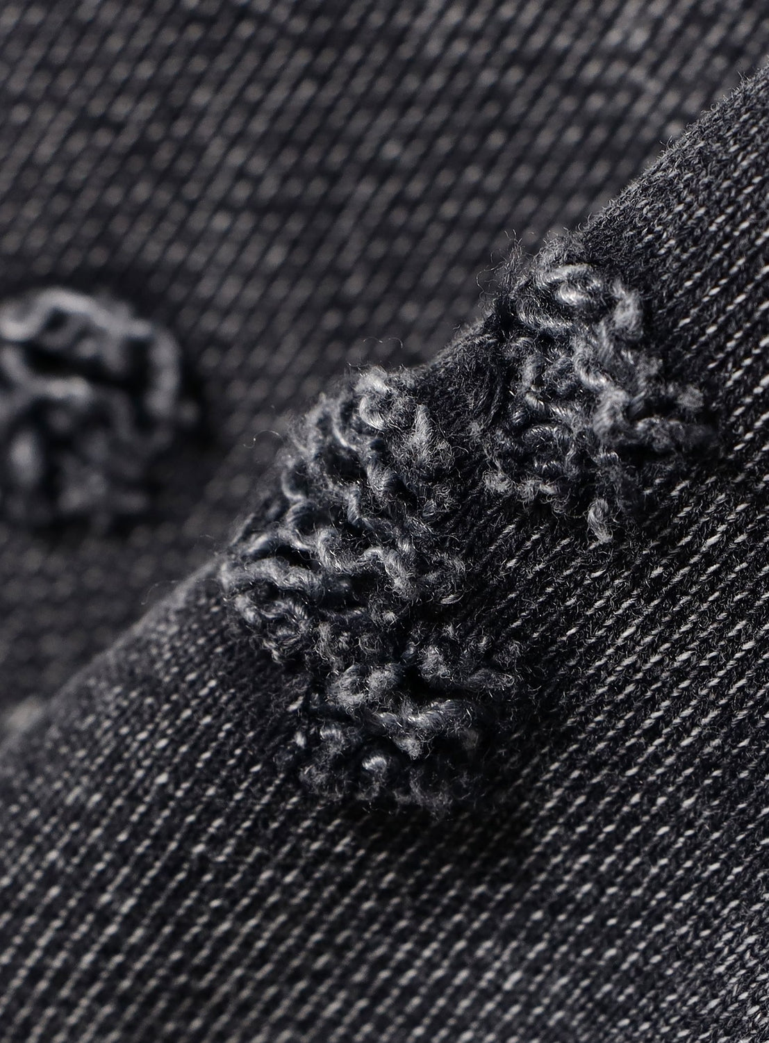 Close-up of BEAMS Wide Short Fit Distressed Heavyweight Hoodie’s dark denim, highlighting its pilled, fuzzy texture and clear diagonal weave for a vintage-inspired look.