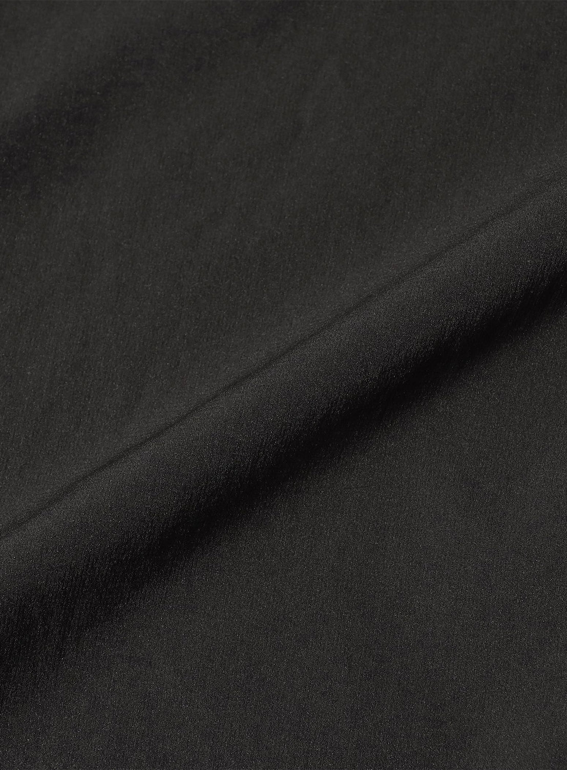 Close-up of black water-repellent fabric from the BEAMS Technical 2-Way Adjustable Easy Pants, showing a visible diagonal fold.