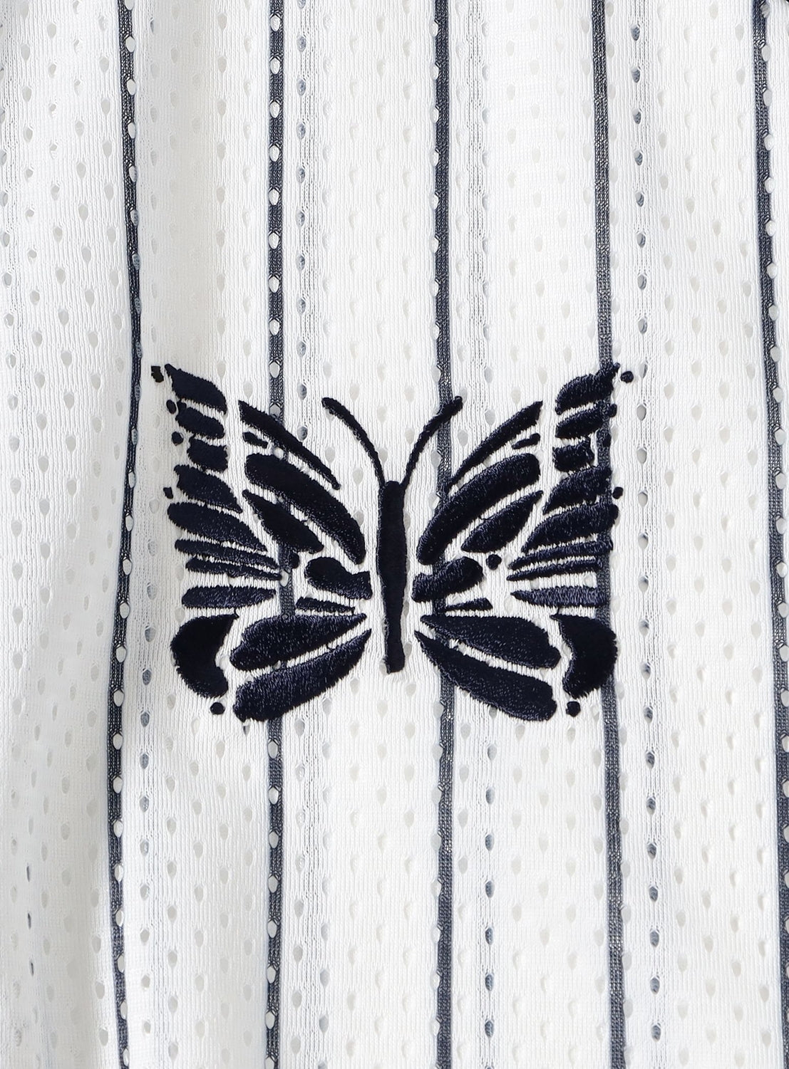 A black butterfly motif is embroidered on a white, textured [Exclusive] Needles 50th Baseball Shirt from NEEDLES, featuring vertical blue pinstripes and subtle dotted details that capture the signature streetwear flair of this special edition.