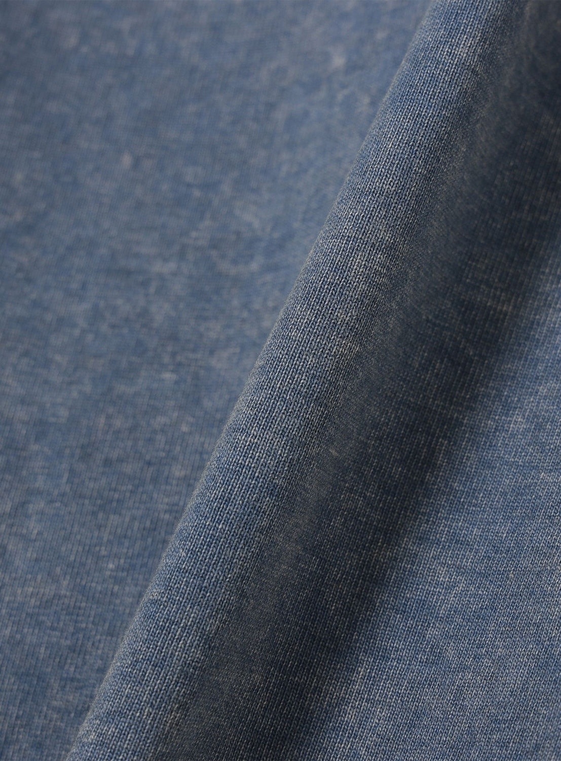 Close-up of blue Ultra Faded Crew Neck T-Shirt from BEAMS, highlighting the detailed weave texture and diagonal fold for a vintage-inspired look.