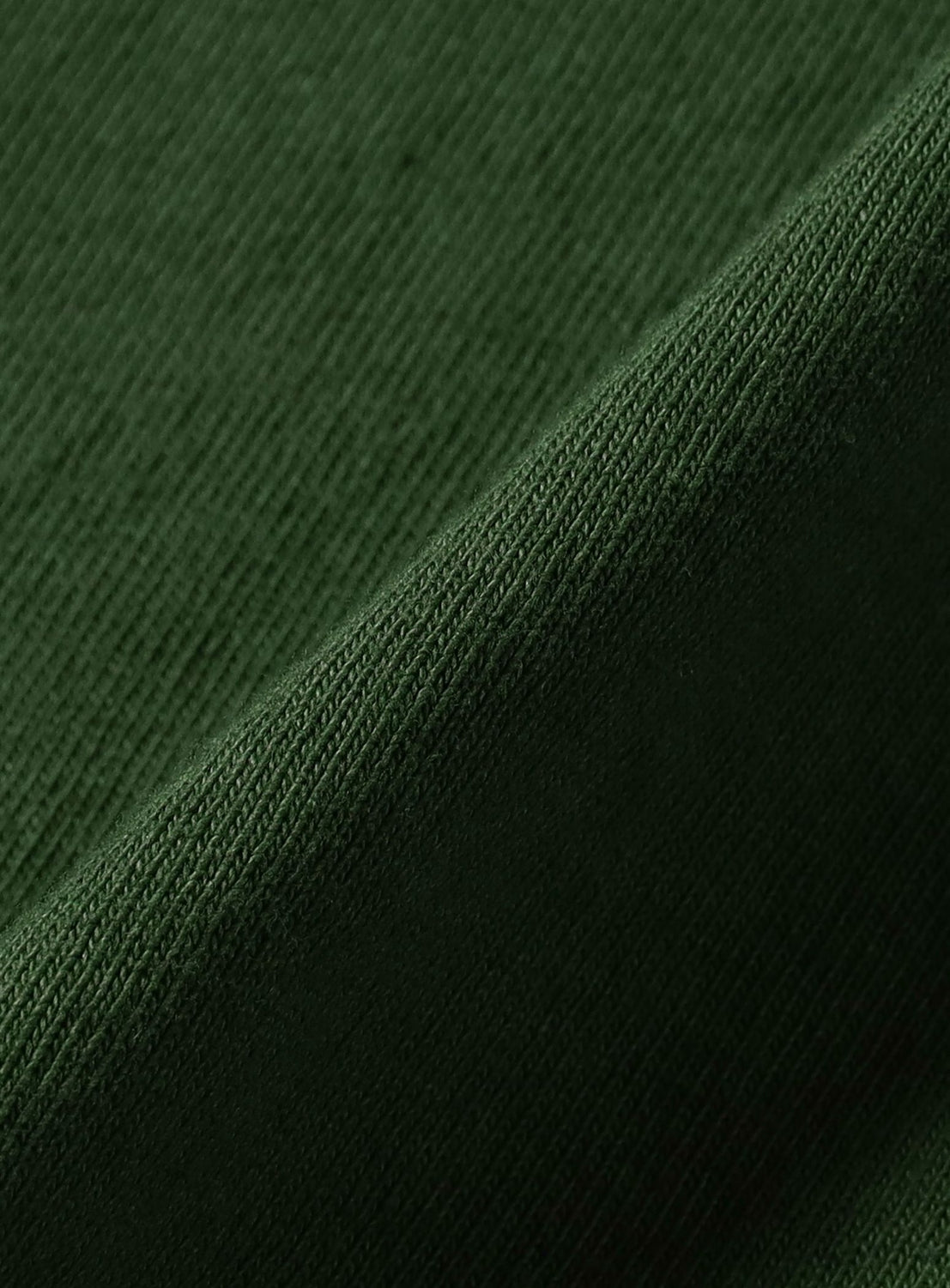 Close-up of a folded piece of dark green fabric from the hi-dutch T-shirt by BEAMS T, showing its fine, ribbed texture and detailed weave—part of the BEAMS 50th anniversary collaboration.